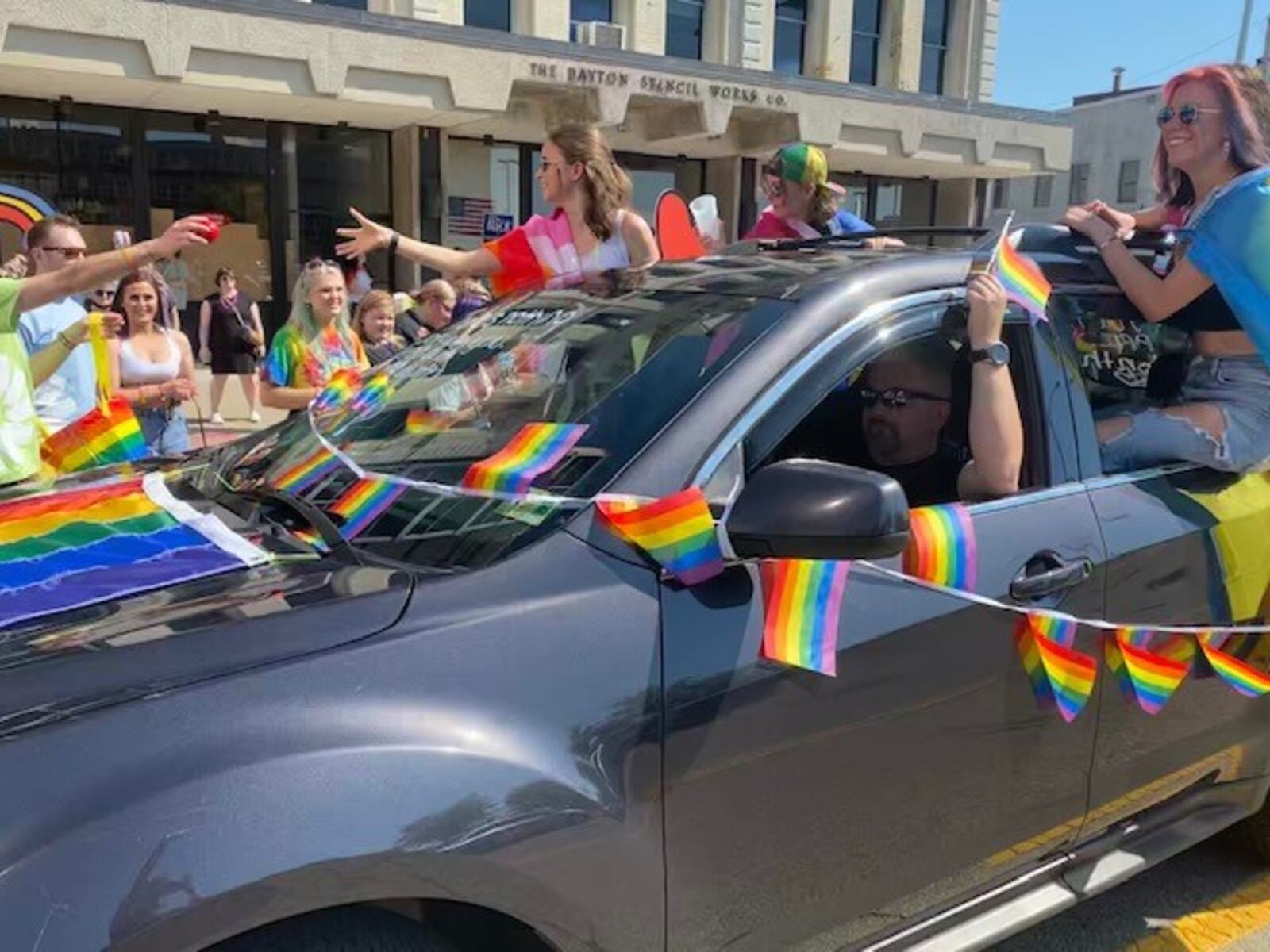 Pride celebrations were well underway at the Greater Dayton LGBT Center reverse parade last year. Cars were decked out in bright colors, adorned with rainbow flags and hearts. In the air there were bubbles, car horns and chants of "love is love." Community allies passed out candy, snacks, and informational brochures to participants. The parade was followed by an LGBTQ+ Pride Festival at Courthouse Square.