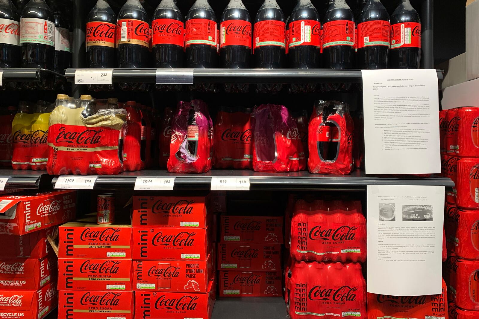 A note is posted next to cleared cases of soft drinks sitting on a shelf in a supermarket in Antwerp, Belgium, after Coca-Cola recalled some of its soft drinks in Europe, Tuesday, Jan. 28, 2025. (AP Photo/Virginia Mayo)