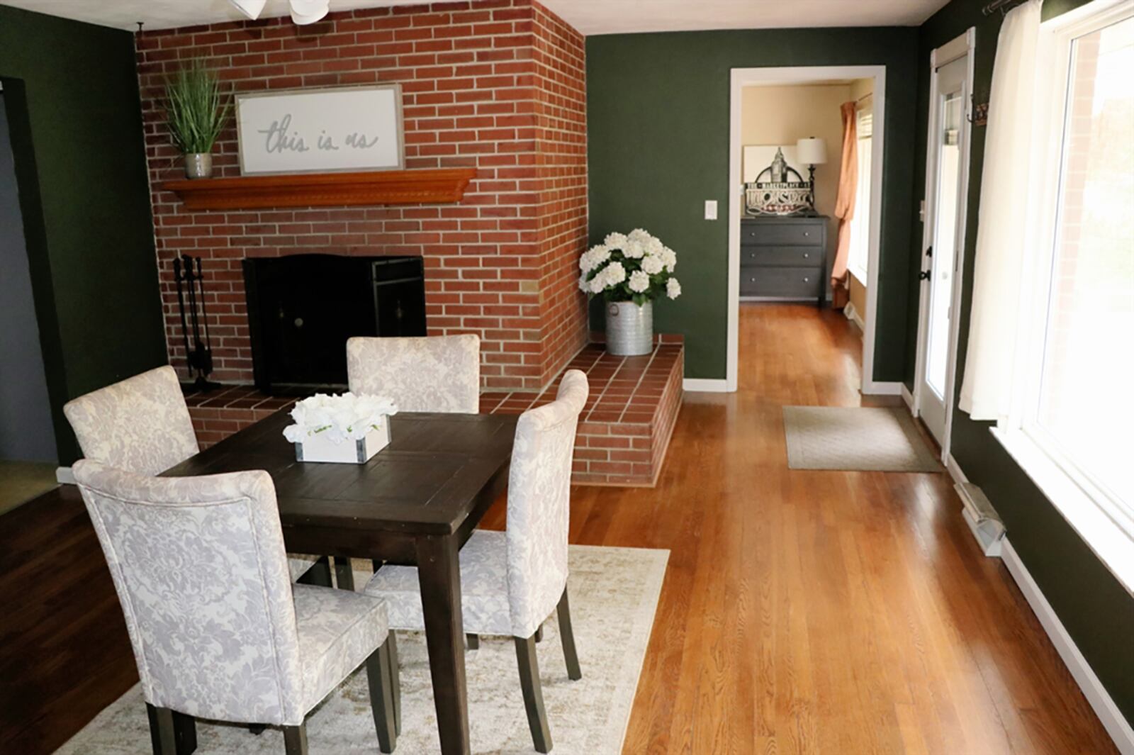 The same wood-burning fireplace from the living room gives the dining room a hearth room setting as the raised hearth wraps around from the side to the front of the fireplace. The fireplace has a dentil wood mantel. CONTRIBUTED PHOTO BY KATHY TYLER