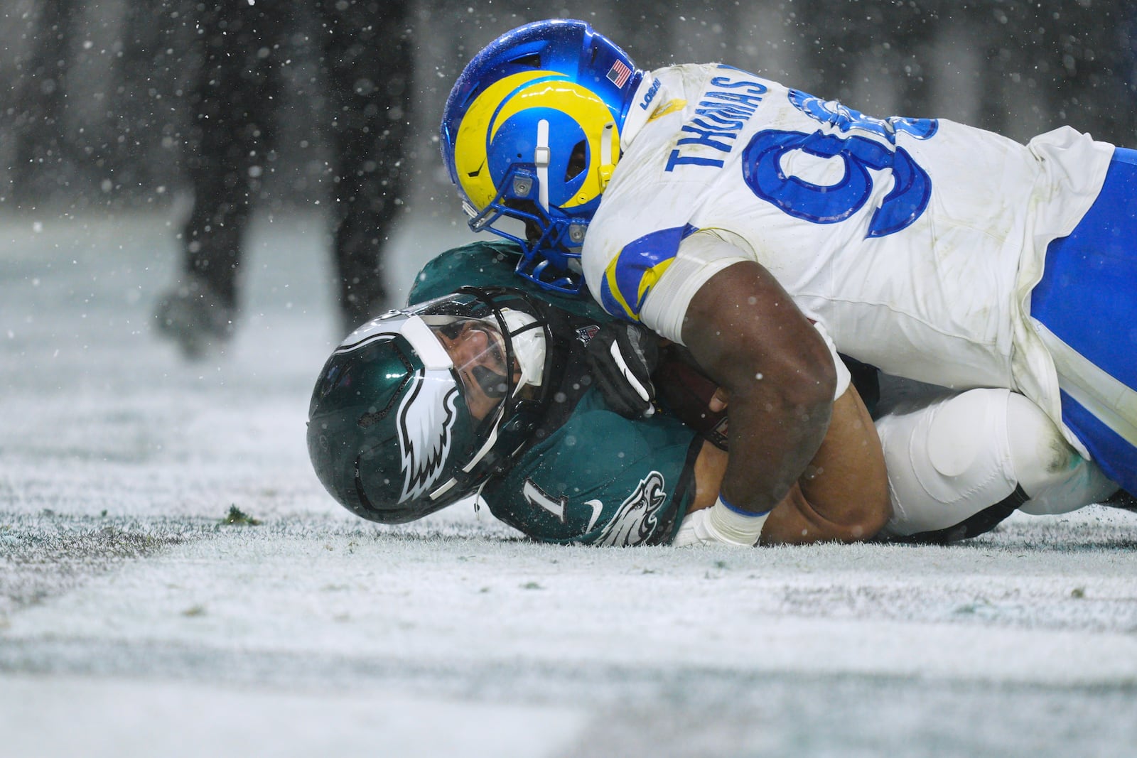 Philadelphia Eagles quarterback Jalen Hurts (1) is tackled by Los Angeles Rams linebacker Keir Thomas (96) during the second half of an NFL football NFC divisional playoff game Sunday, Jan. 19, 2025, in Philadelphia. (AP Photo/Derik Hamilton)