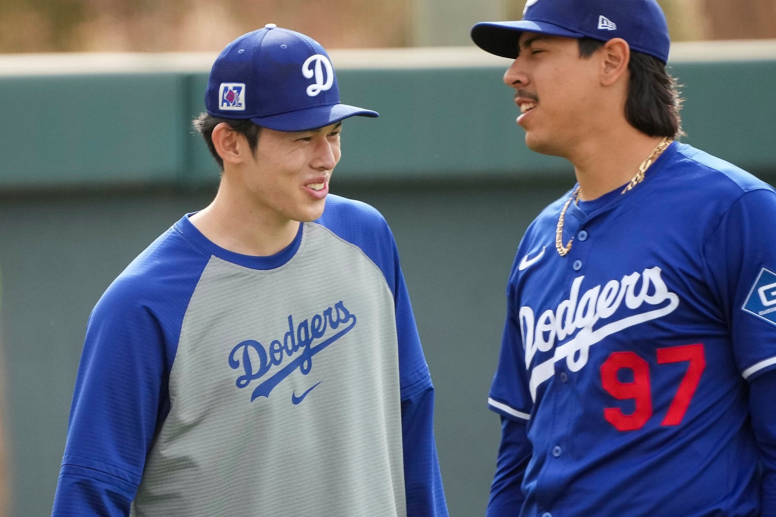 Los Angeles Dodgers pitcher Roki Sasaki, left, laughs with teammate Jose Rodriguez (97) as they stretch during spring training baseball practice, Wednesday, March. 5, 2025, in Phoenix. (AP Photo/Darryl Webb)