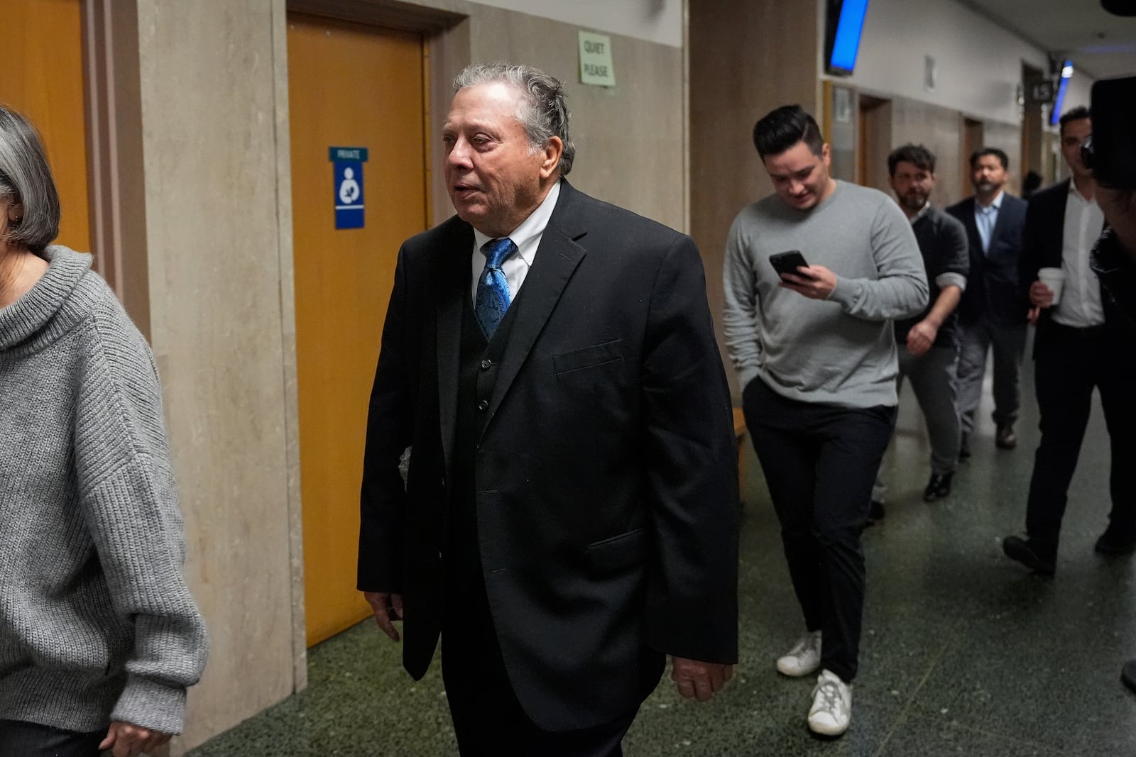 Rick Lee, center, father of Cash App founder Bob Lee, walks to Department 28 to enter the courtroom at the Hall of Justice for the murder trial of Nima Momeni, Tuesday, Dec. 3, 2024, in San Francisco. (AP Photo/Godofredo A. Vásquez)