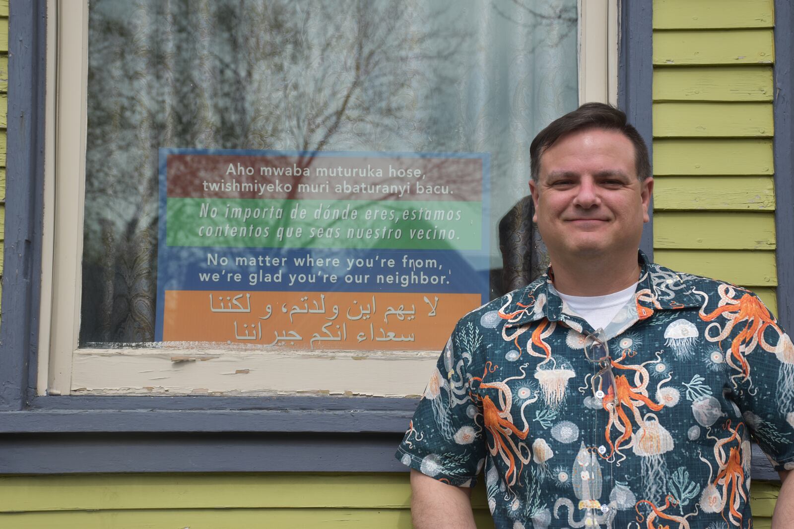 Bill Kennedy, who lives in Dayton’s South Park neighborhood, has a sign in the front window of his home that says in multiple languages, “No matter where you’re from, we’re glad you’re our neighbor.” Kennedy said he'd love to have immigrants live next door. CORNELIUS FROLIK / STAFF