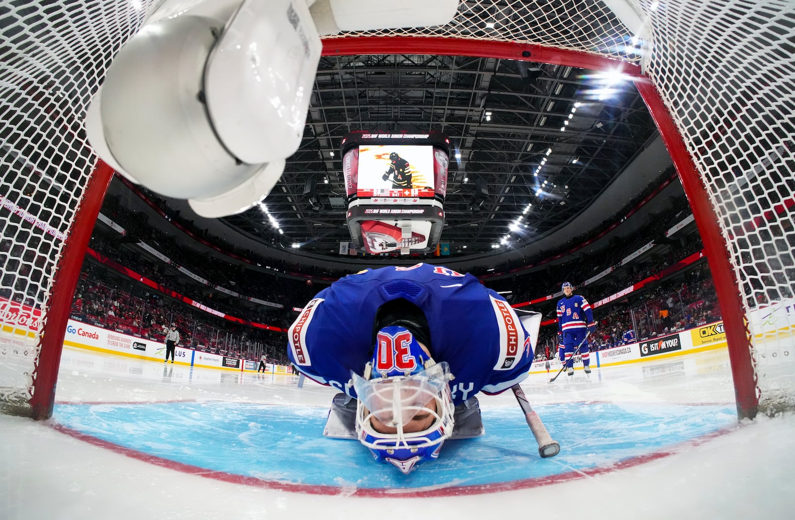 USA goaltender Hampton Slukynsky (30) stretches prior to the start of the third period of a quarterfinal match against Switzerland at the IIHF World Junior Hockey Championship in Ottawa, Ontario Thursday, Jan. 2, 2025. (Sean Kilpatrick/The Canadian Press via AP)