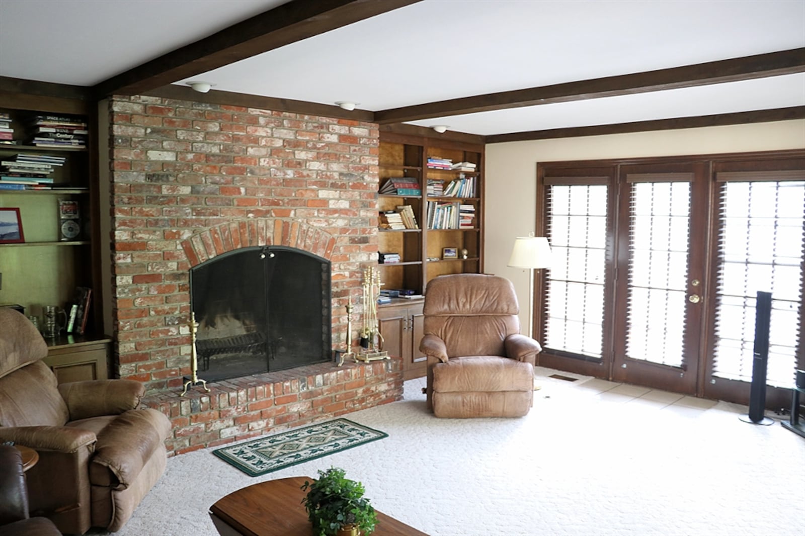 Wood beams accent the ceilings in the great room while complementing the built-in bookcase, fireplace and cabinetry. 