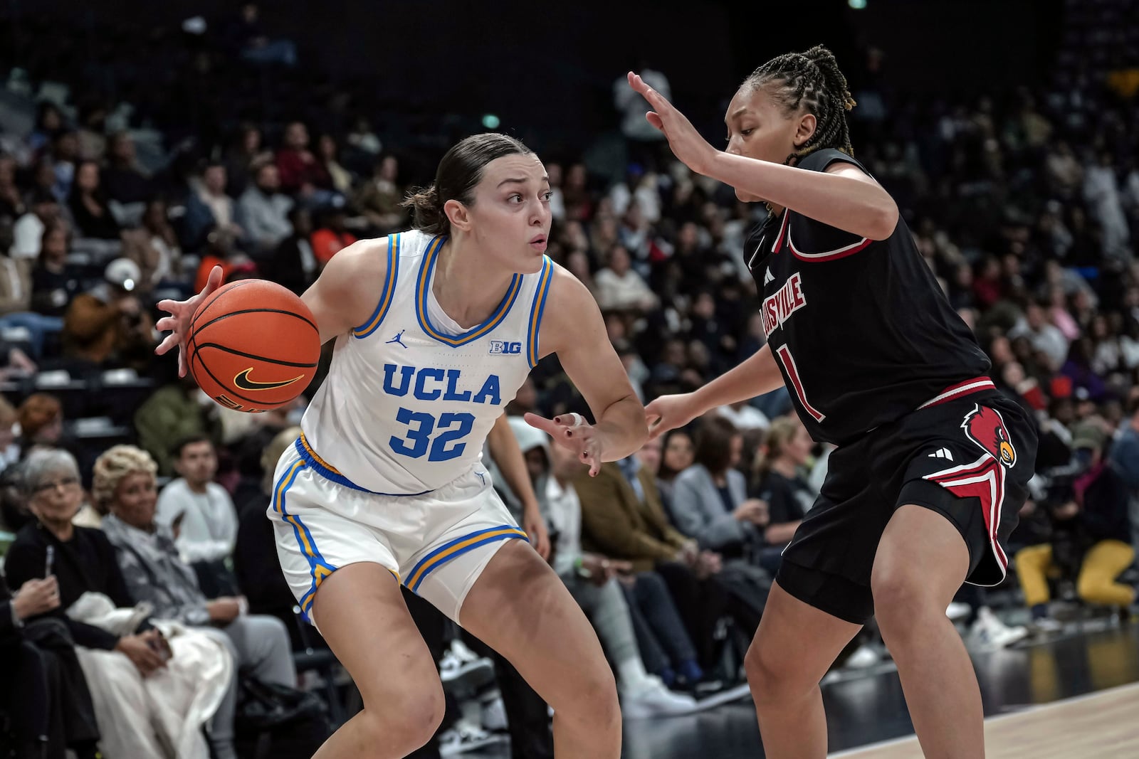 UCLA forward Angela Dugalic, left, controls the ball against Louisville guard Imari Berri, right, during an NCAA college basketball game Monday, Nov. 4, 2024, in Paris, France. (AP Photo/Aurelien Morissard)