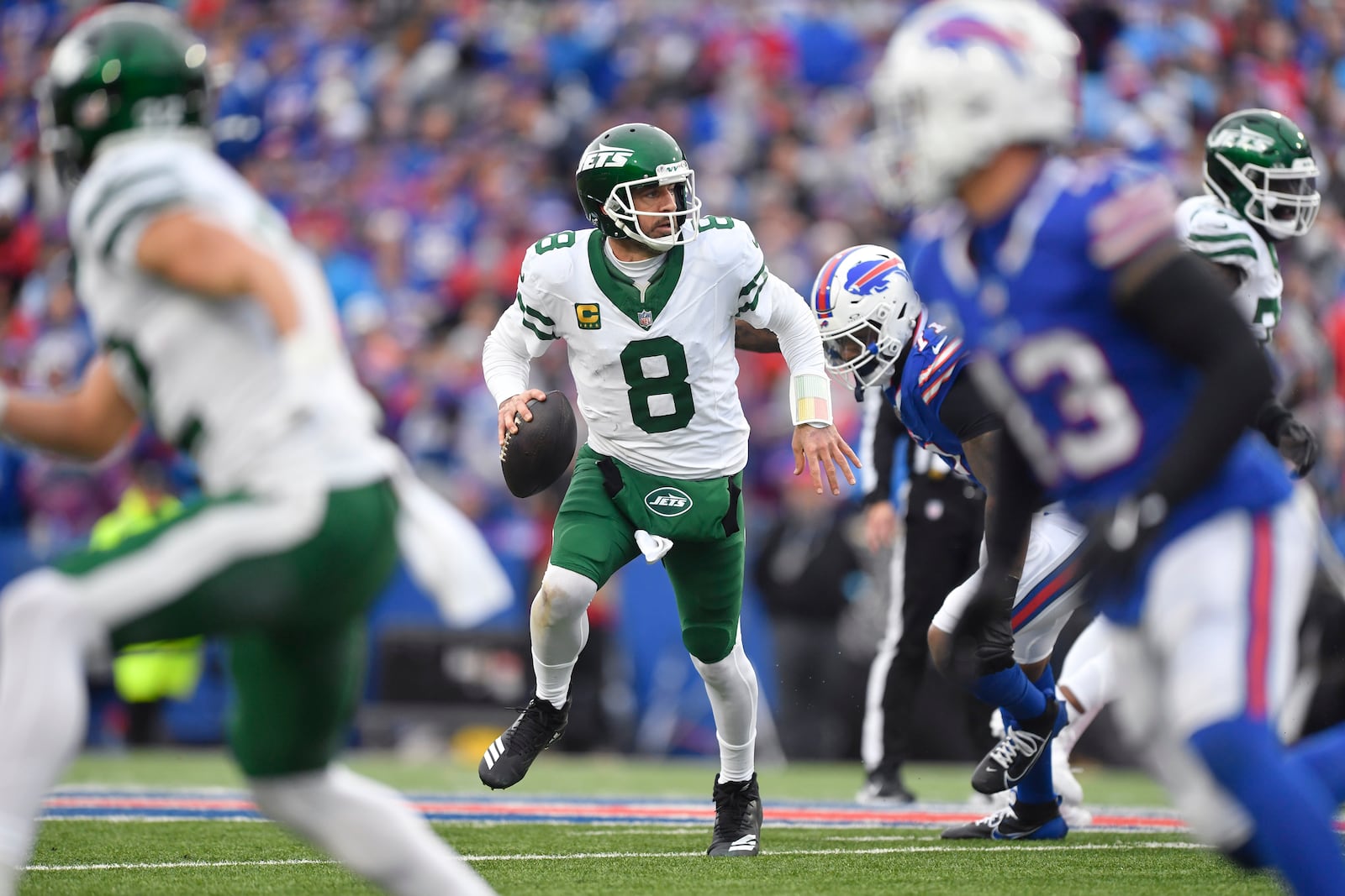 New York Jets quarterback Aaron Rodgers (8) scramble as he looks to pass against the Buffalo Bills during the second half of an NFL football game, Sunday, Dec. 29, 2024, in Orchard Park, N.Y. (AP Photo/Adrian Kraus)