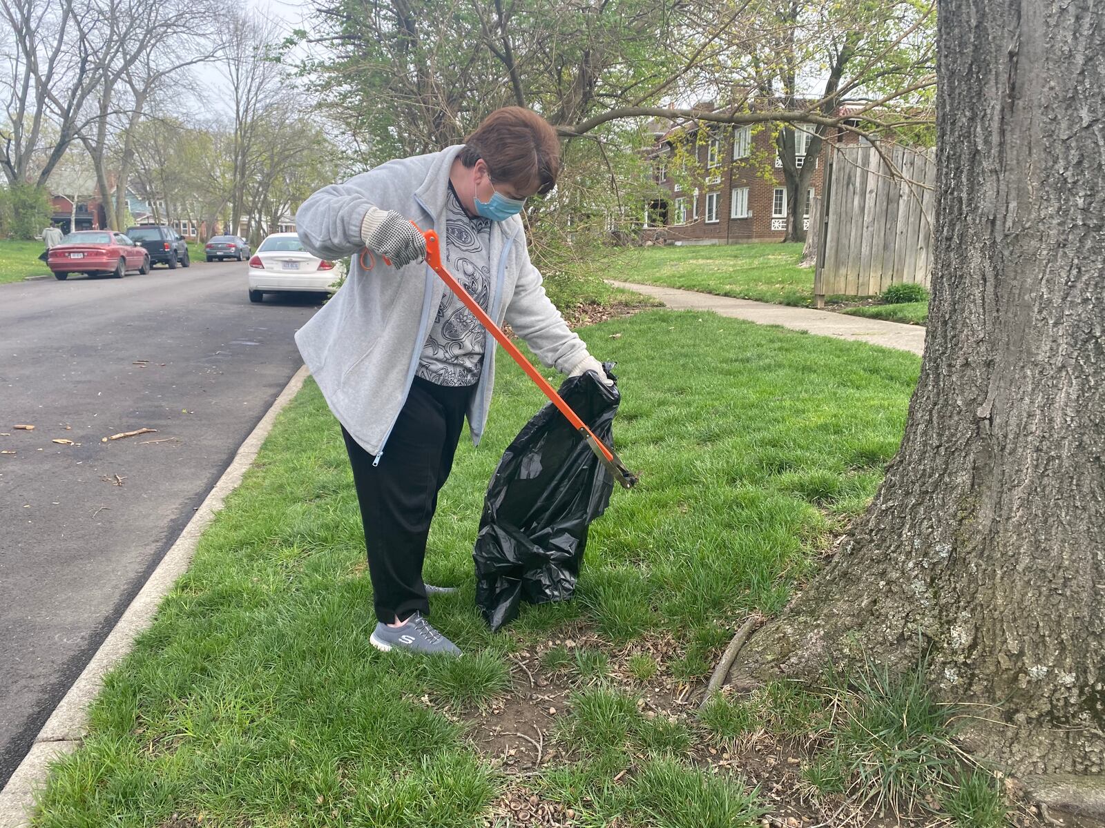 Theresa Cates helps to pick up trash around the Gem City Market on Saturday EILEEN McCLORY / STAFF