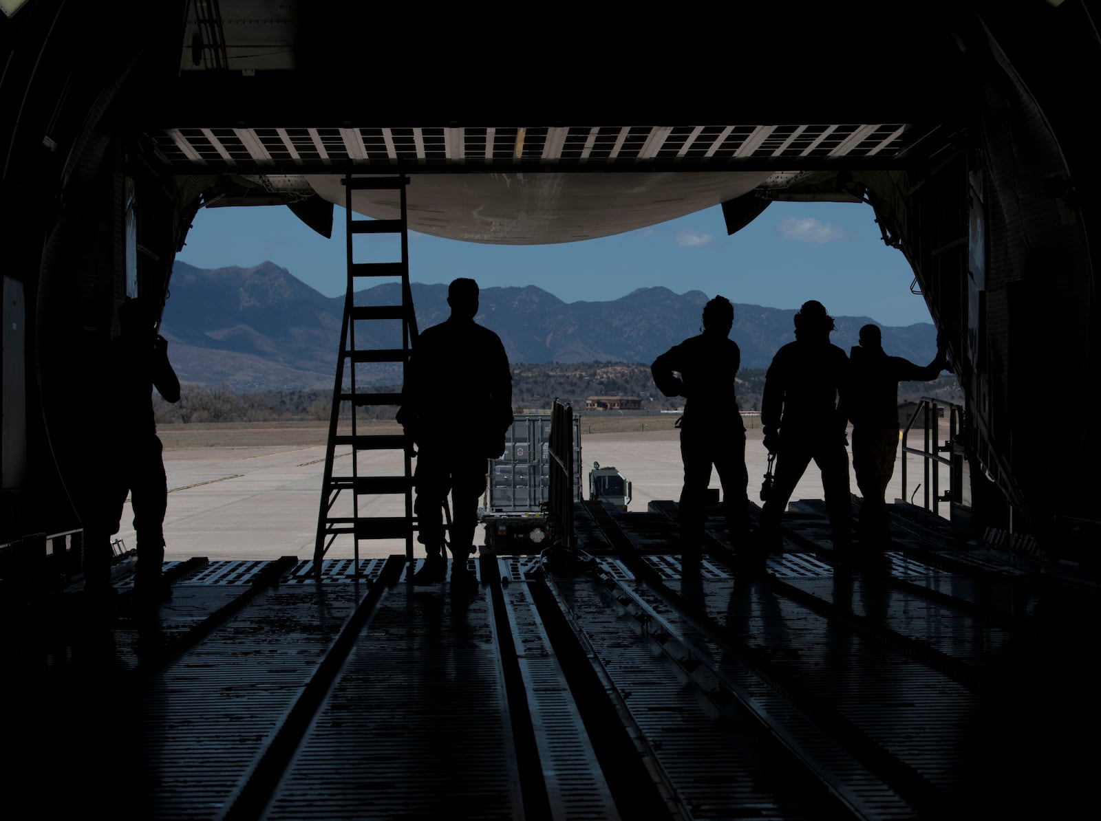 Airmen from the 21st Logistics Readiness Squadron, the 22nd Airlift Squadron watch as a K Loader is directed after putting cargo pallets onto a C-5M Super Galaxy in April on Peterson Air Force Base, Colo. Peterson AFB photo