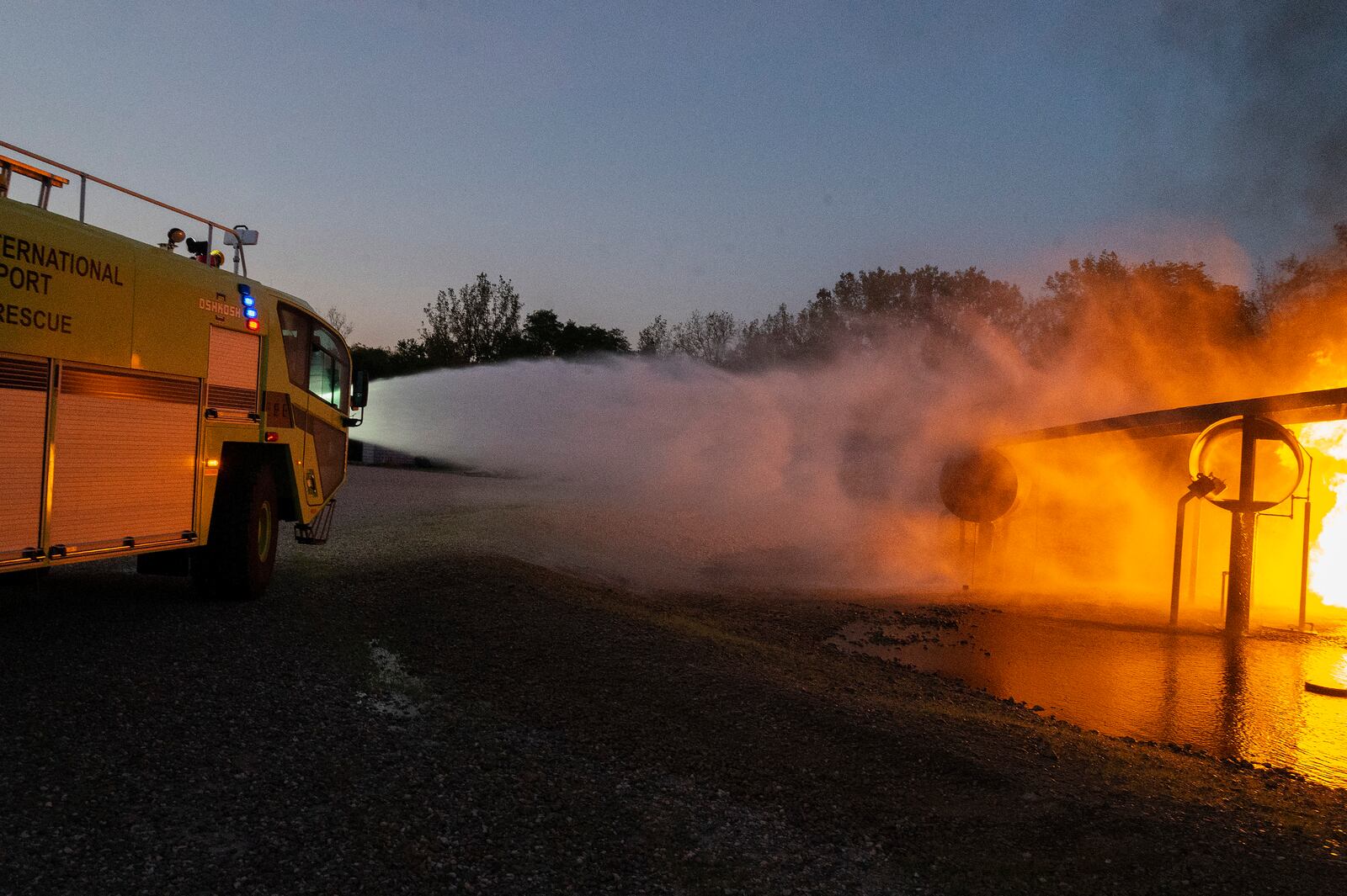 The Dayton International Airport Fire Department crash truck sprays down a live training fire Oct. 5 at Wright-Patterson Air Force Base. The 788th Civil Engineer Squadron Fire Department hosts outside agencies, including fire departments from the Springfield, Columbus and Dayton airports, to give them the opportunity to work on aircraft-fire skills. (U.S. Air Force photo by R.J. Oriez)