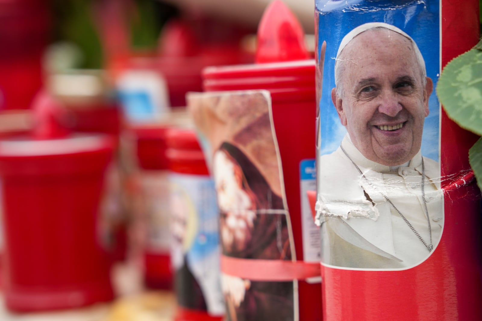 A candle with a portrait of Pope Francis is seen in front of the Agostino Gemelli Polyclinic, in Rome, Tuesday, Feb. 18, 2025, where Pope Francis has been hospitalised to undergo some necessary diagnostic tests and to continue his ongoing treatment for bronchitis. (AP Photo/Andrew Medichini)