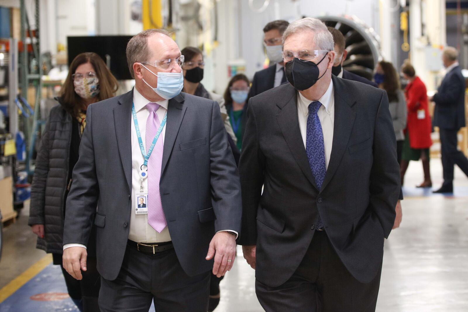 A GE Aviation photo showing GE engineer Chris Lorence on the left, and U.S. Secretary of Agriculture Thomas Vilsack on the right, walking and talking in GE Aviation's Development Assembly shop.