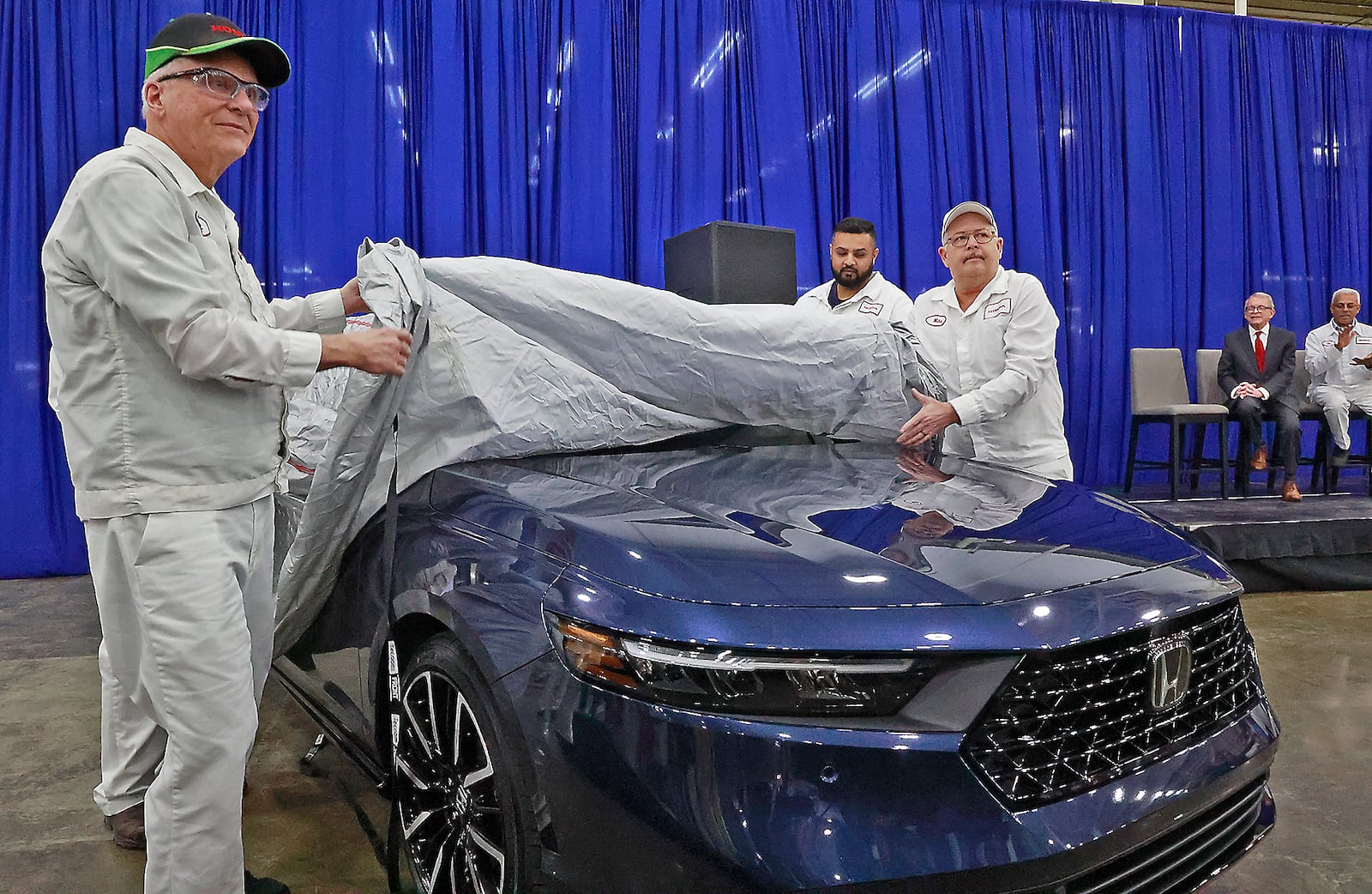 Honda associates Rick VanGundy, left, and Mike Rausch, right, unveil the new 2023 Honda Accord as Governor Mike DeWine looks on in the background Thursday, Jan. 5, 2023. Both VanGunday and Rausch have worked at the Honda Marysville Plant since it opened. BILL LACKEY/STAFF