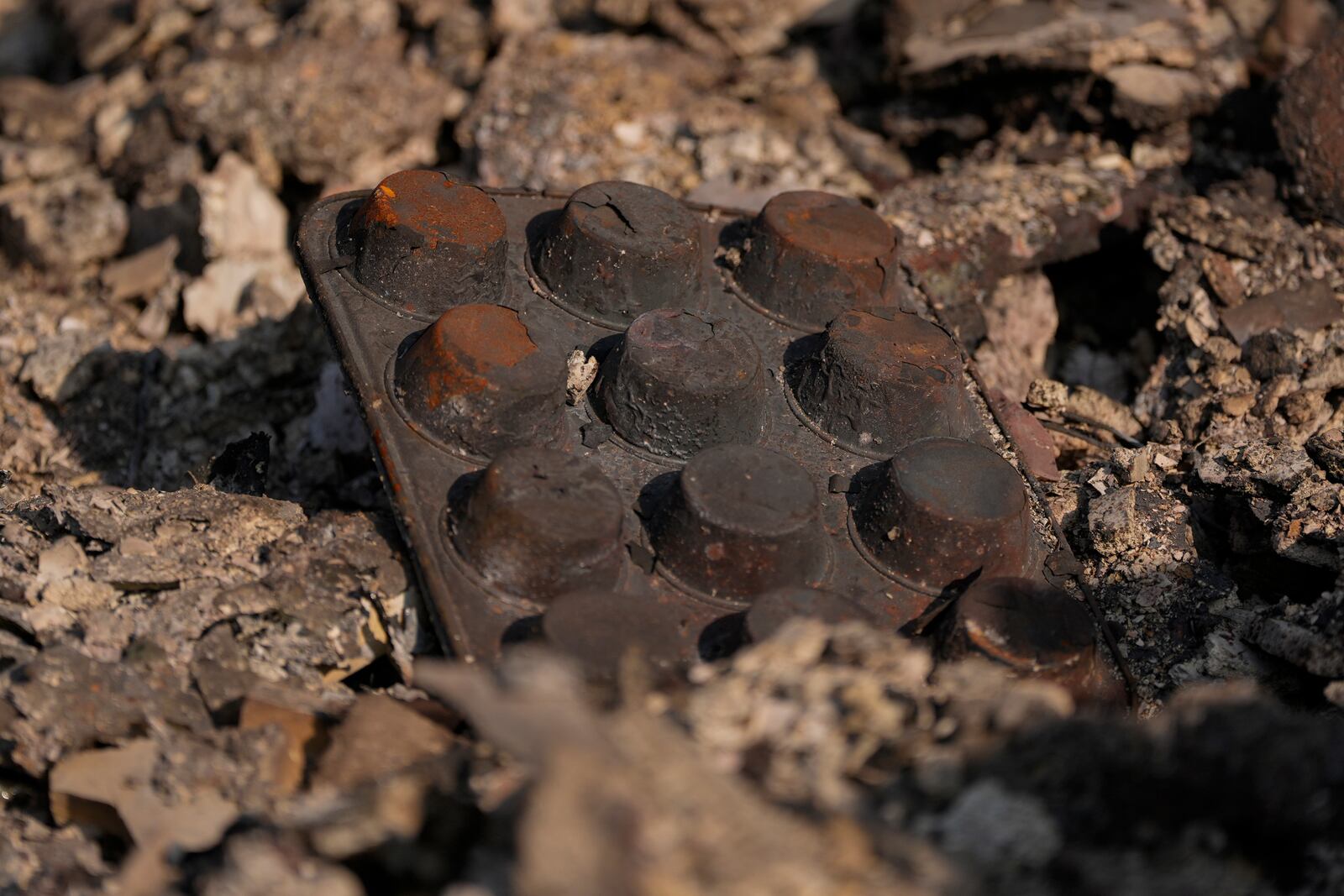 Charred muffin tins poke out of the rubble of what remains of Chef Daniel Shemtob's home destroyed by the Palisades Fire, Sunday, Jan. 19, 2025, in the Pacific Palisades neighborhood of Los Angeles, Calif. (AP Photo/Carolyn Kaster)