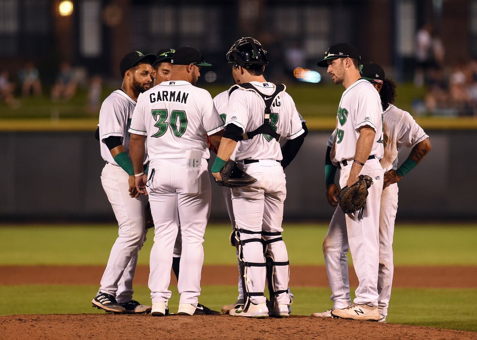 Dragons pitching coach Brian Garman meets with the infielders during a recent game at Day Air Ballpark. Nick Falzerano/CONTRIBUTED