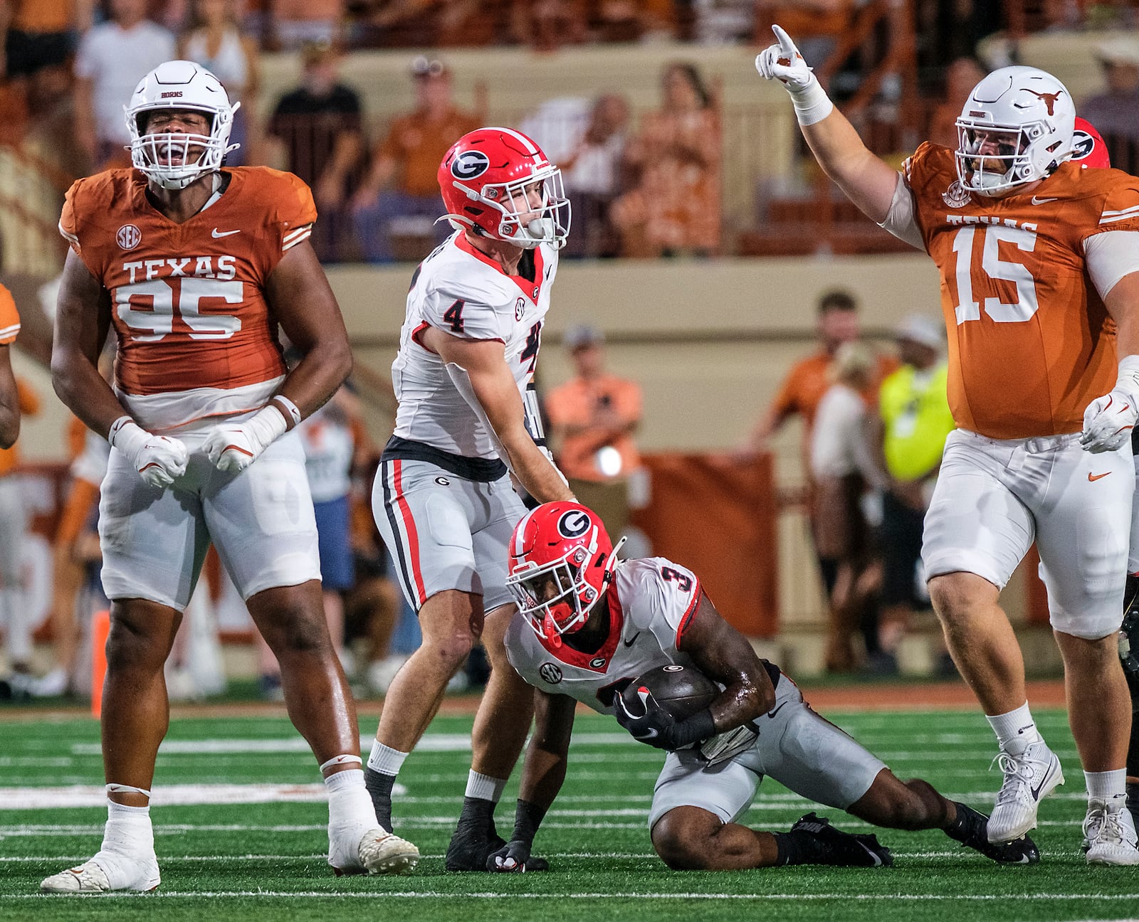 Texas defensive lineman Alfred Collins (95) and defensive lineman Bill Norton (15) celebrate a stop against Georgia running back Nate Frazier (3) as Georgia tight end Oscar Delp (4) looks on during the first half of an NCAA college football game in Austin, Texas, Saturday, Oct. 19, 2024. (AP Photo/Rodolfo Gonzalez)