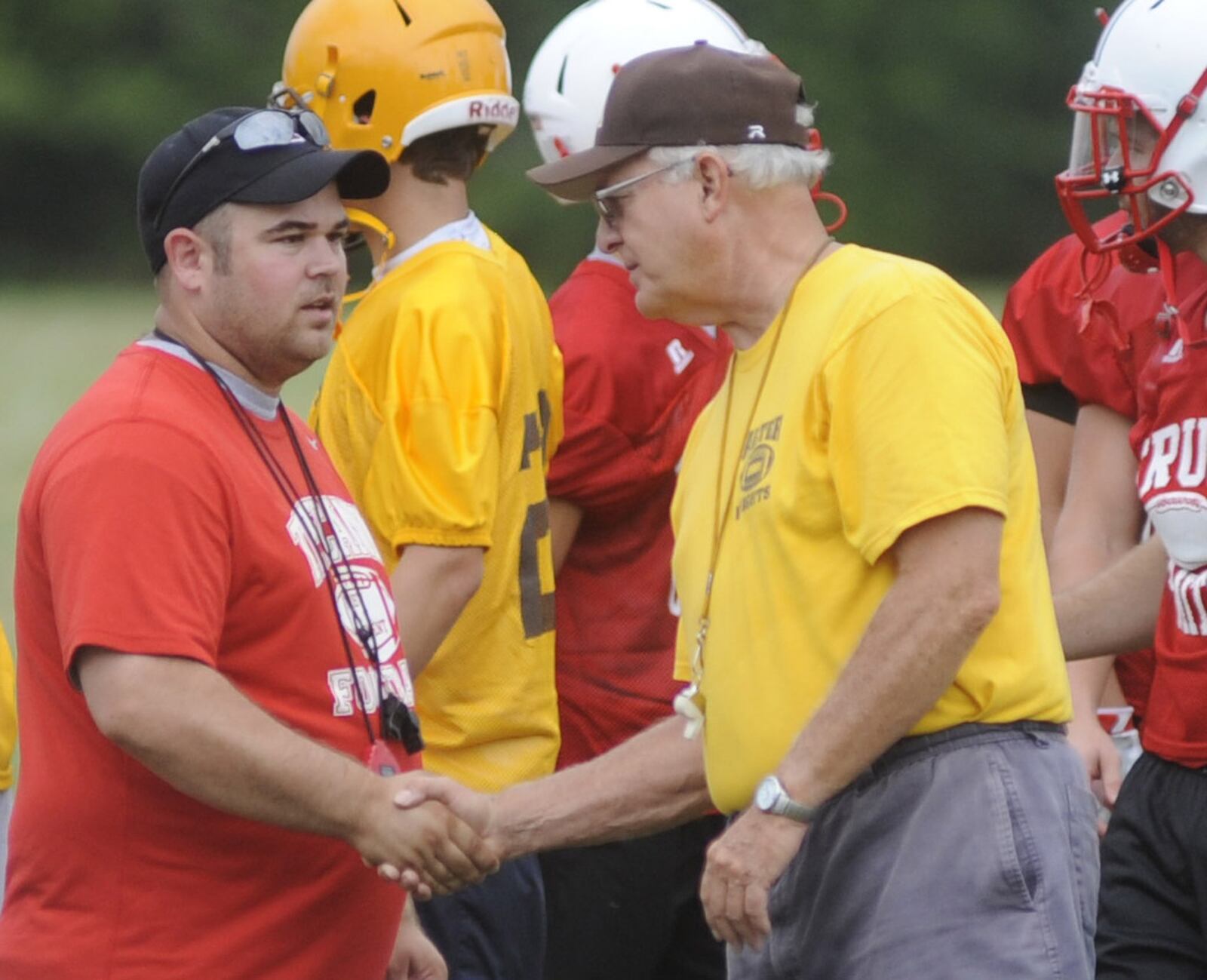 Tipp head football coach Joel Derge (left) greeted Alter coach Ed Domsitz during a 7-on-7 passing scrimmage in July of 2016. MARC PENDLETON / STAFF