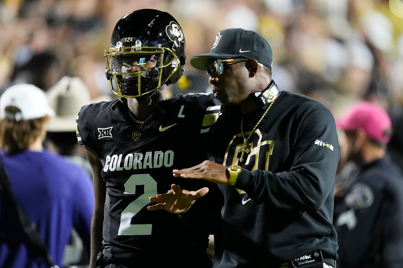 Colorado head coach Deion Sanders, right, confers with quarterback Shedeur Sanders in the first half of an NCAA college football game against Kansas State, Saturday, Oct. 12, 2024, in Boulder, Colo. (AP Photo/David Zalubowski)