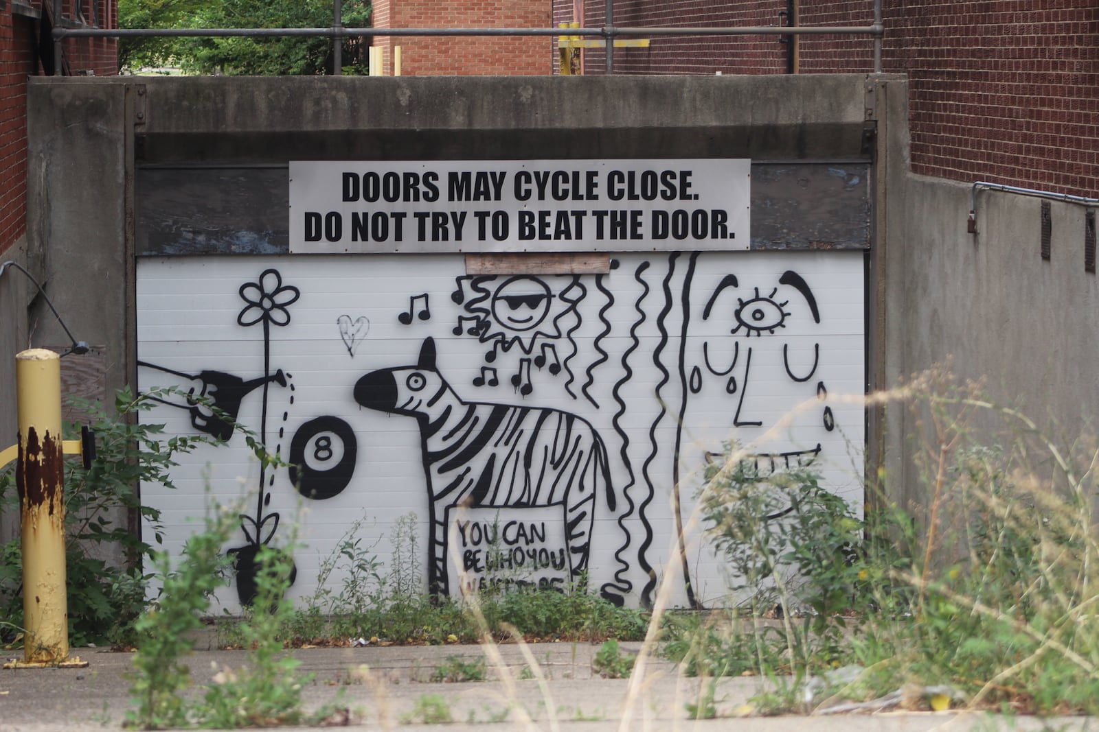 Graffiti on a garage door on a vacant property on West First Street in downtown Dayton. CORNELIUS FROLIK / STAFF