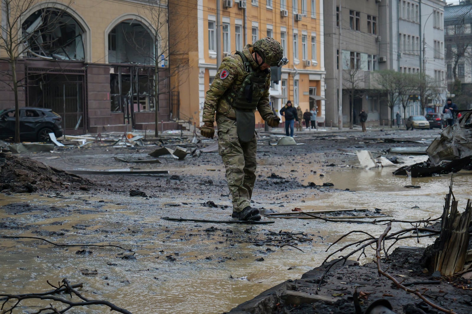 A Ukrainian serviceman collects evidence following recent Russian attacks in Kyiv, Ukraine, Friday, Dec. 20, 2024. (AP Photo/Daniil Bashakov)