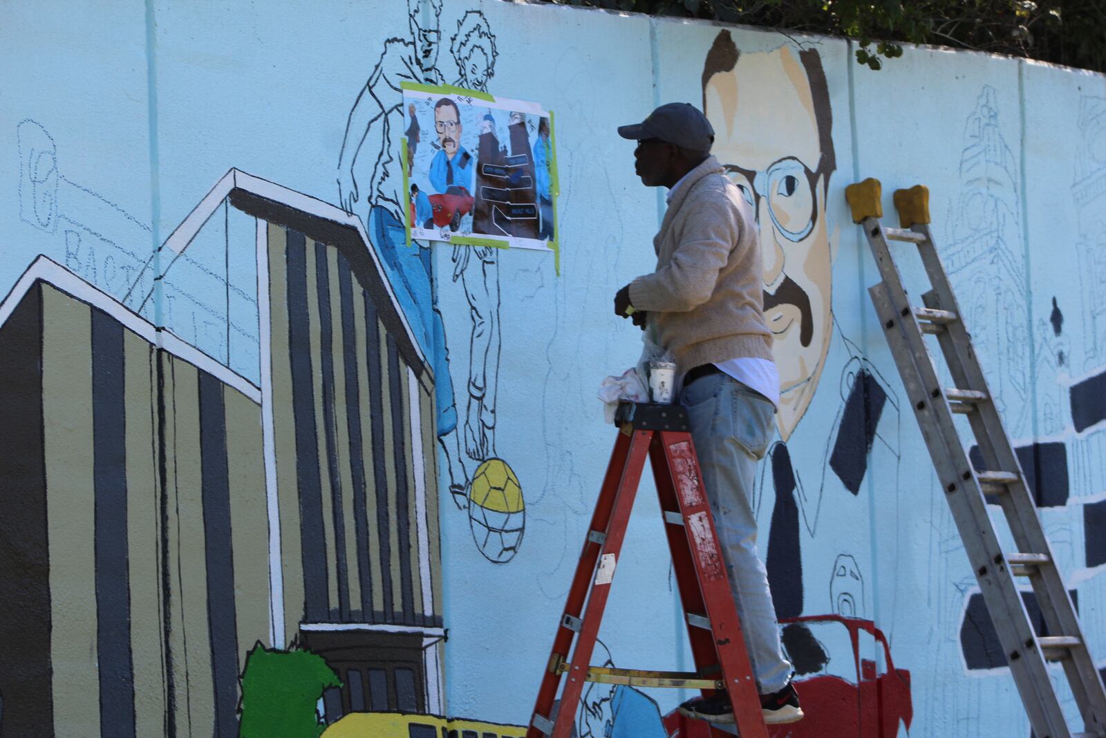 Artist Morris Howard works on the new Steve Whalen memorial mural on Friday. CORNEILUS FROLIK / STAFF