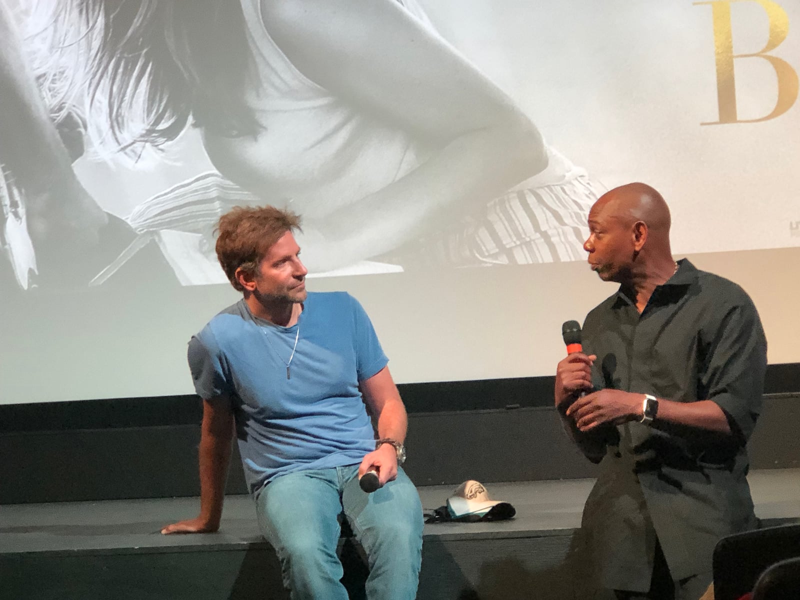 Bradley Cooper and Dave Chappelle address the crowd at a private screening of "A Star is Born." The film featuring Cooper, Lady Gaga and Chappelle is Cooper's directorial debut. AMELIA ROBINSON/STAFF