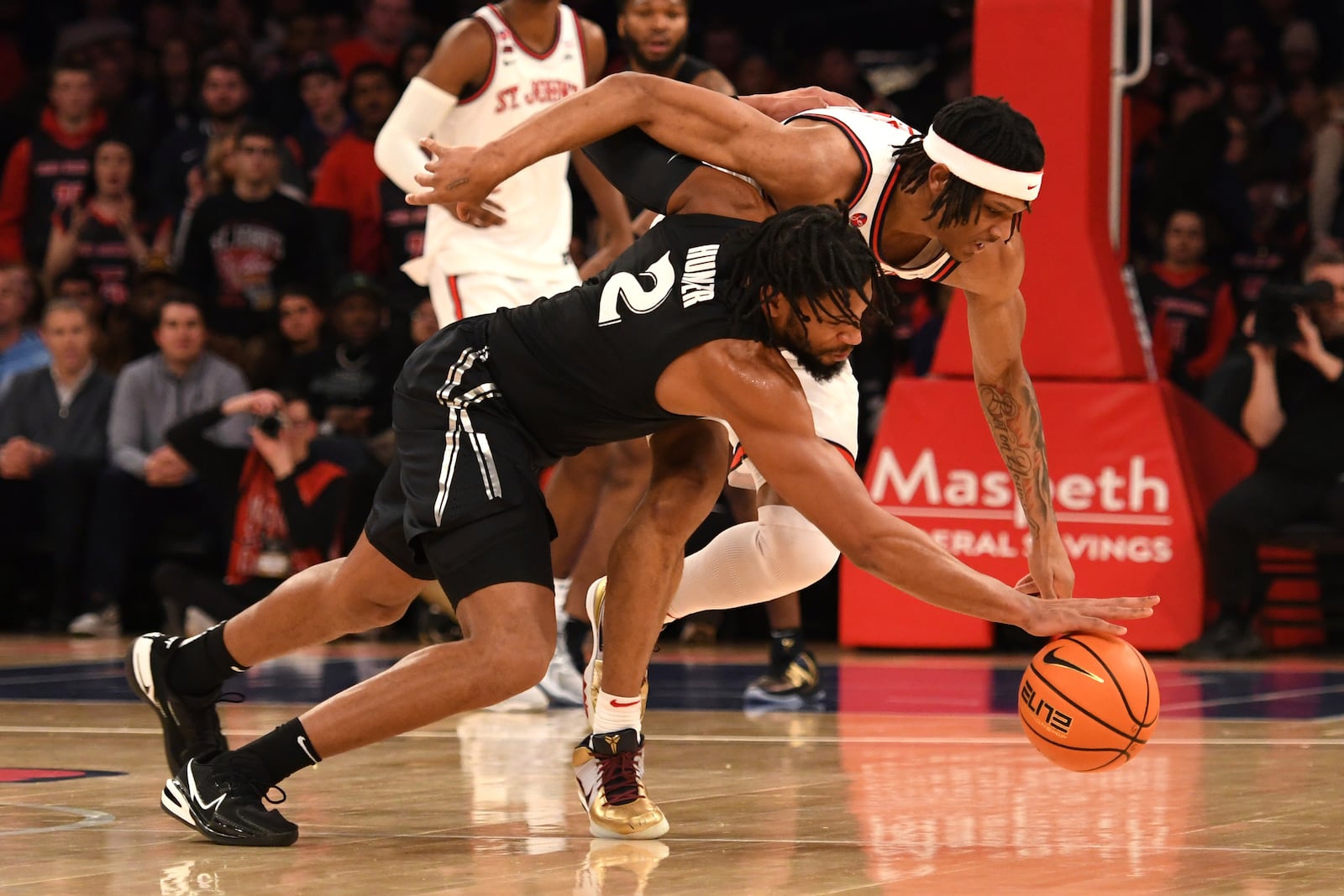 Xavier forward Jerome Hunter (2) and St. John's guard Aaron Scott, right, dive for the ball during the first half of an NCAA college basketball game Wednesday, Jan. 22, 2025, in New York. (AP Photo/Pamela Smith)