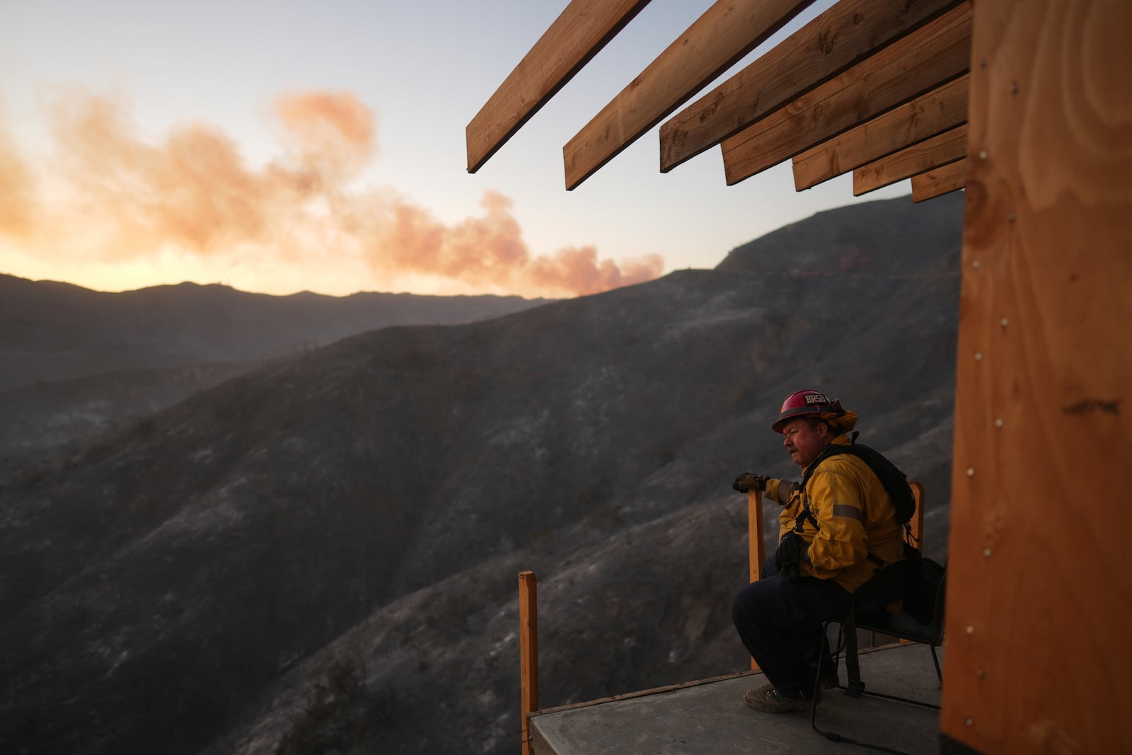 A firefighter rests as crews battle the Palisades Fire in Mandeville Canyon, Saturday, Jan. 11, 2025, in Los Angeles. (AP Photo/Eric Thayer)