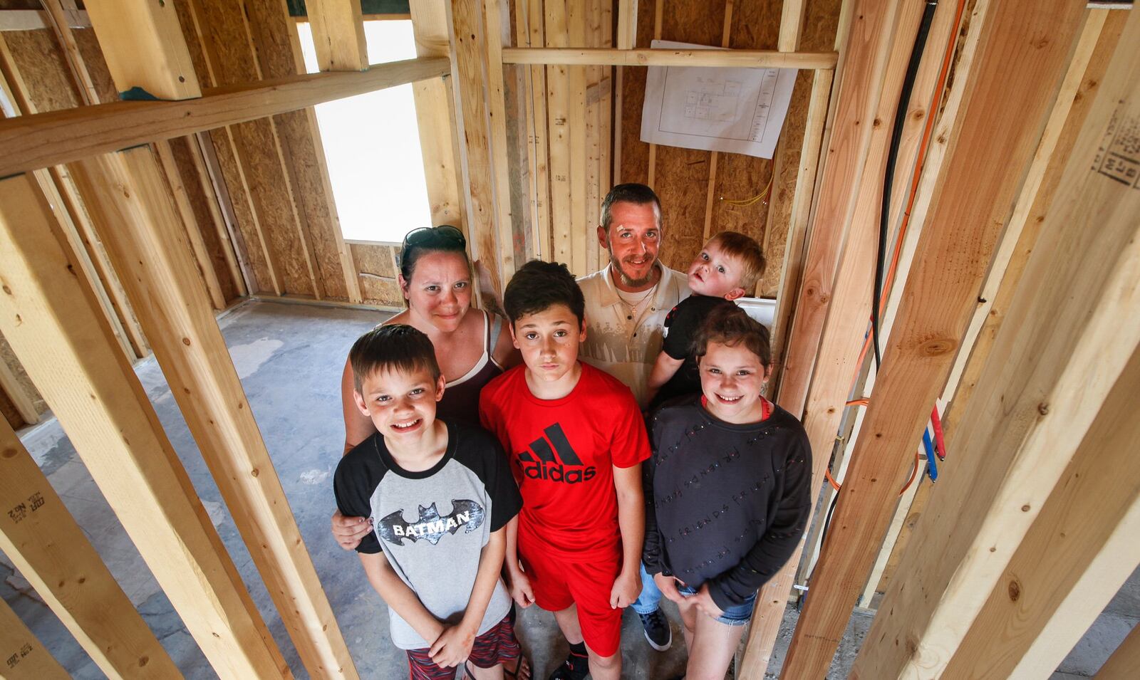 Gloria and Kevin Pennington spent harrowing minutes with their children Noah, 13, 10-year-old twins, Ayden and Alyson, and Owen, 2, as the EF4 Memorial Day tornado took apart their Brookville home. Pictured in the same area of the house where they rode out the storm, the family are among survivors rebuilding in Terrace Park. CHRIS STEWART / STAFF