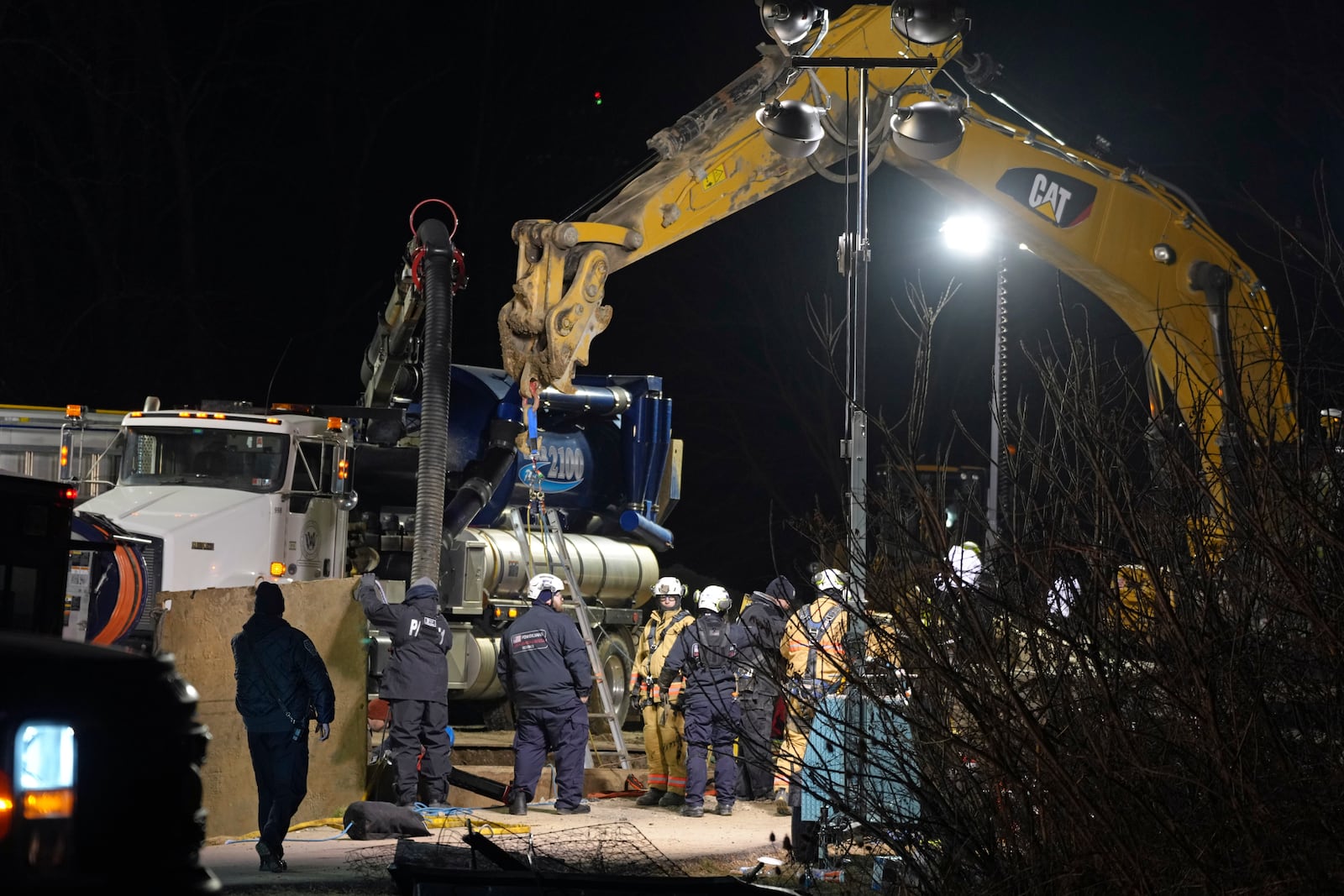 Rescue workers search through the night in a sinkhole for Elizabeth Pollard, who disappeared while looking for her cat, in Marguerite, Pa., Tuesday, Dec. 3, 2024. (AP Photo/Gene J. Puskar)