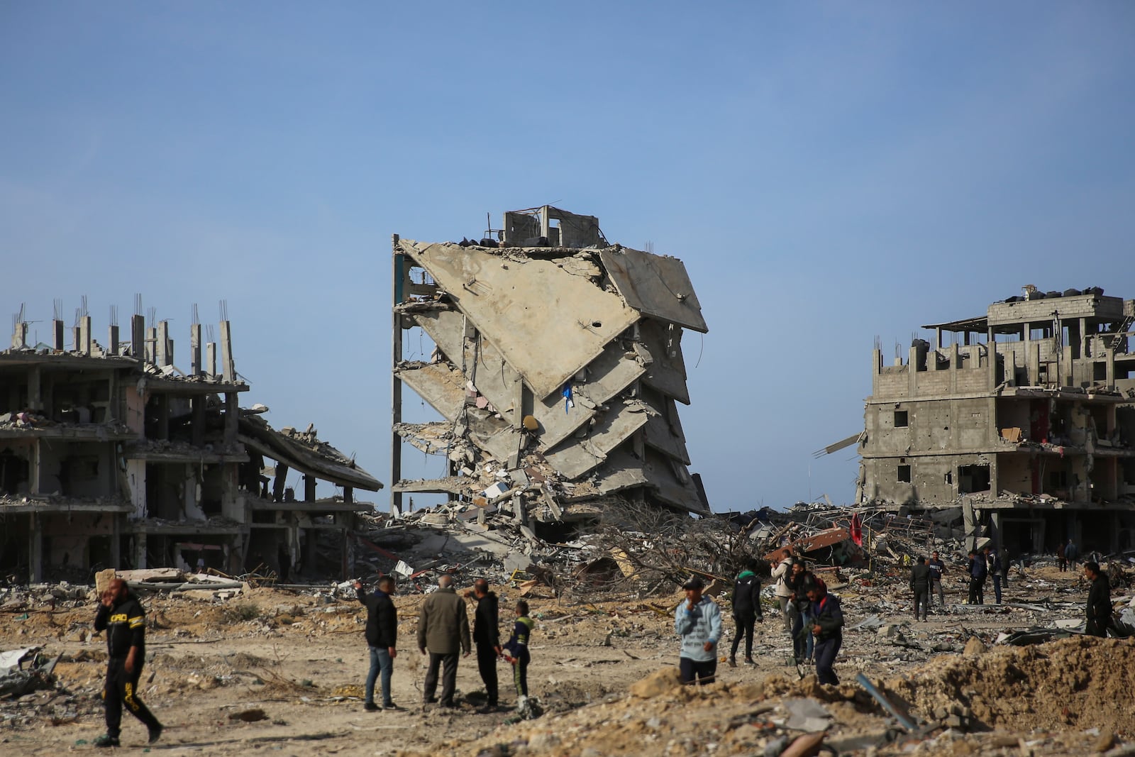 Palestinians inspect the destruction caused by the Israeli air and ground offensive, Sunday, Jan. 19, 2025, in Rafah, as a ceasefire deal between Israel and Hamas went into effect. (AP Photo/Mohammad Hajjar)