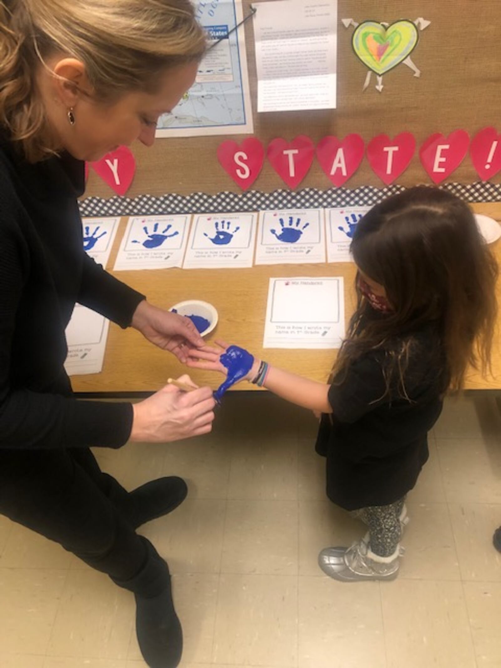 Alyce Haren, left, works with a student to make a handprint to put in the students' time capsule. Students will open the capsules in March 2033. Courtesy of Alyce Haren.