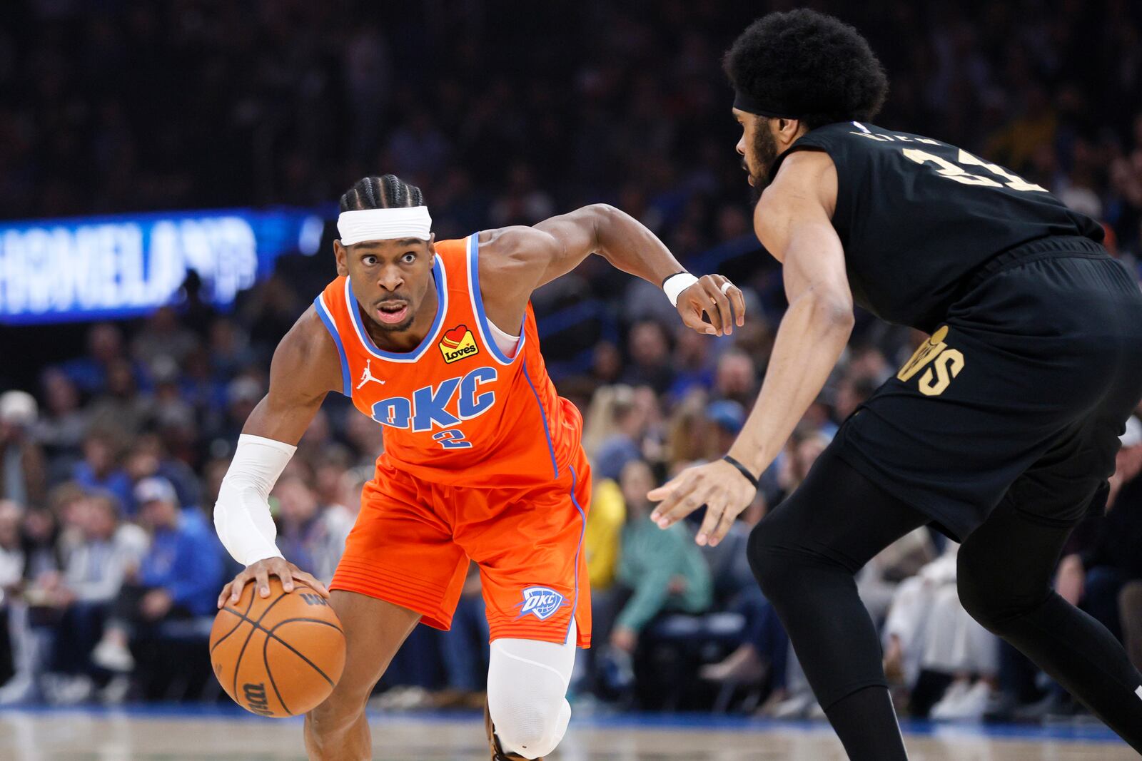 Oklahoma City Thunder guard Shai Gilgeous-Alexander, left, drives against Cleveland Cavaliers center Jarrett Allen, right, during the first half of an NBA basketball game Thursday, Jan. 16, 2025, in Oklahoma City. (AP Photo/Nate Billings)