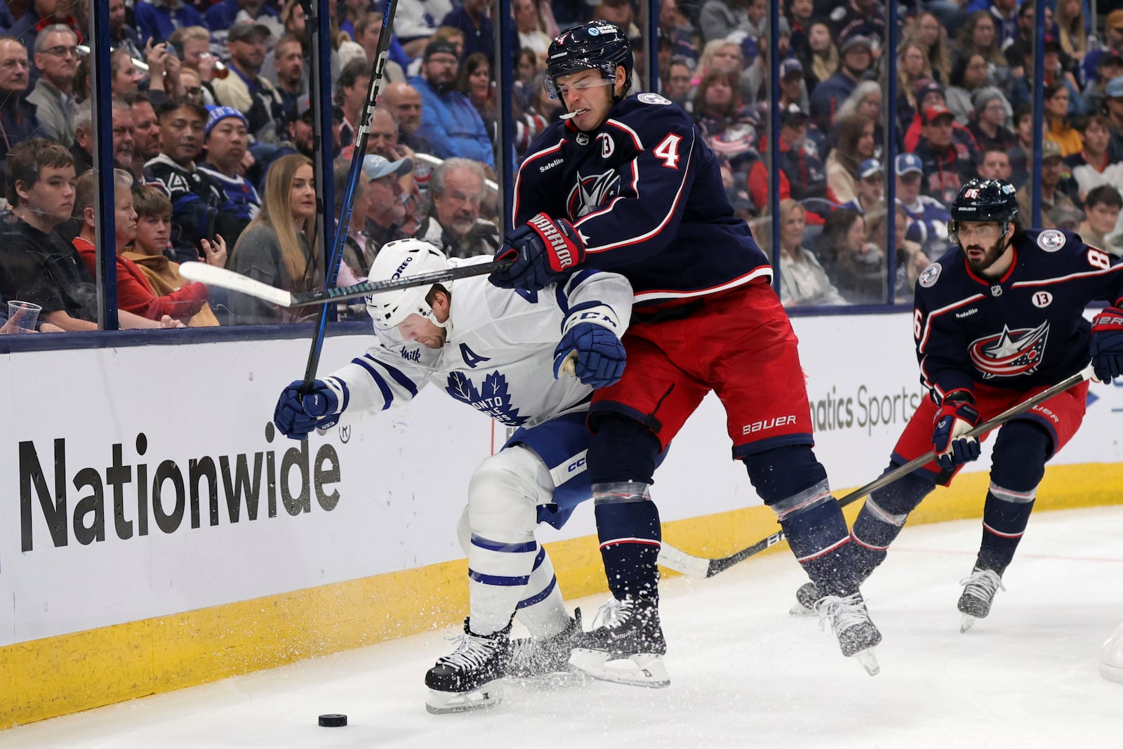 Columbus Blue Jackets forward Cole Sillinger, right, reaches for the puck behind Toronto Maple Leafs defenseman Morgan Rielly during the second period of an NHL hockey game in Columbus, Ohio, Tuesday, Oct. 22, 2024. (AP Photo/Paul Vernon)