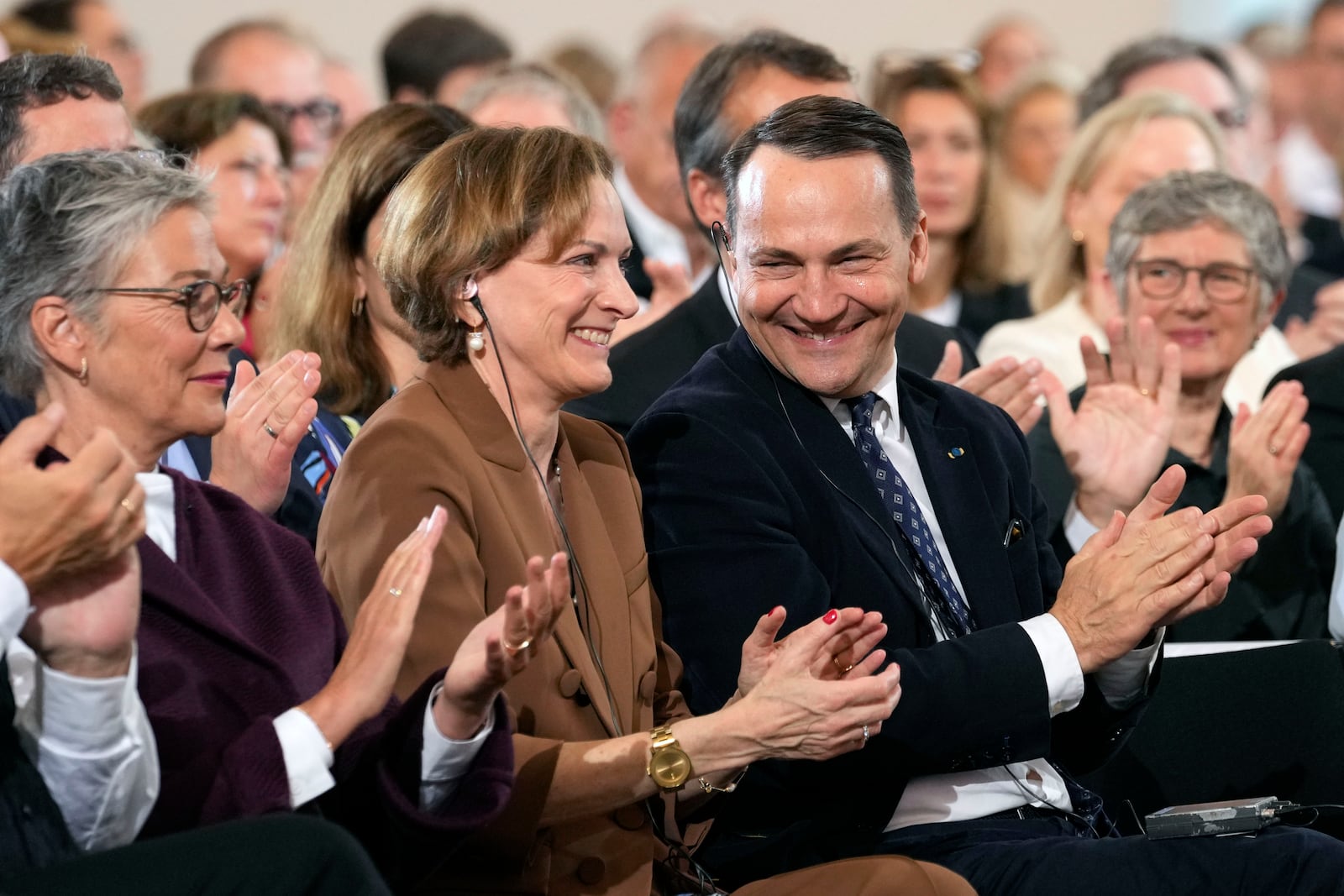 American journalist and historian Anne Applebaum claps hands with her husband Poland's Foreign Minister Radosław Sikorski during the Peace Prize of the German Book Trade ceremony for Anne Applebaum at the St. Paul's Church in Frankfurt, Germany, Sunday, Oct. 20, 2024.(AP Photo/Martin Meissner, Pool)