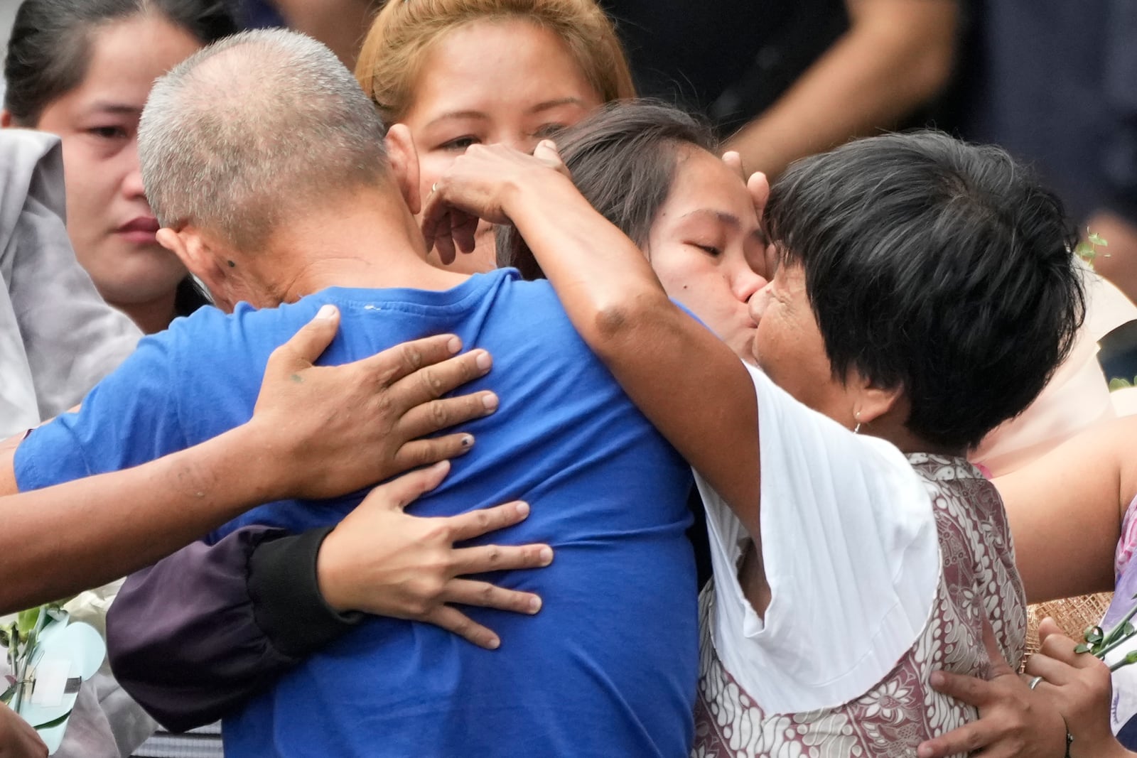 Mary Jane Veloso, center, a Filipino woman who spent almost 15 years in an Indonesian prison for drug trafficking and was nearly executed by firing squad in 2015, kisses her mother as she is reunited with her family at the Correctional Institution for Women in Mandaluyong, Philippines Wednesday, Dec. 18, 2024. (AP Photo/Aaron Favila)