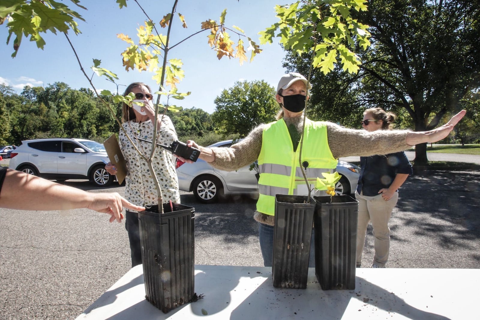 Valerie Claggett of Five Rivers MetroParks directs staff at the Healing Nature tree giveaway Friday.