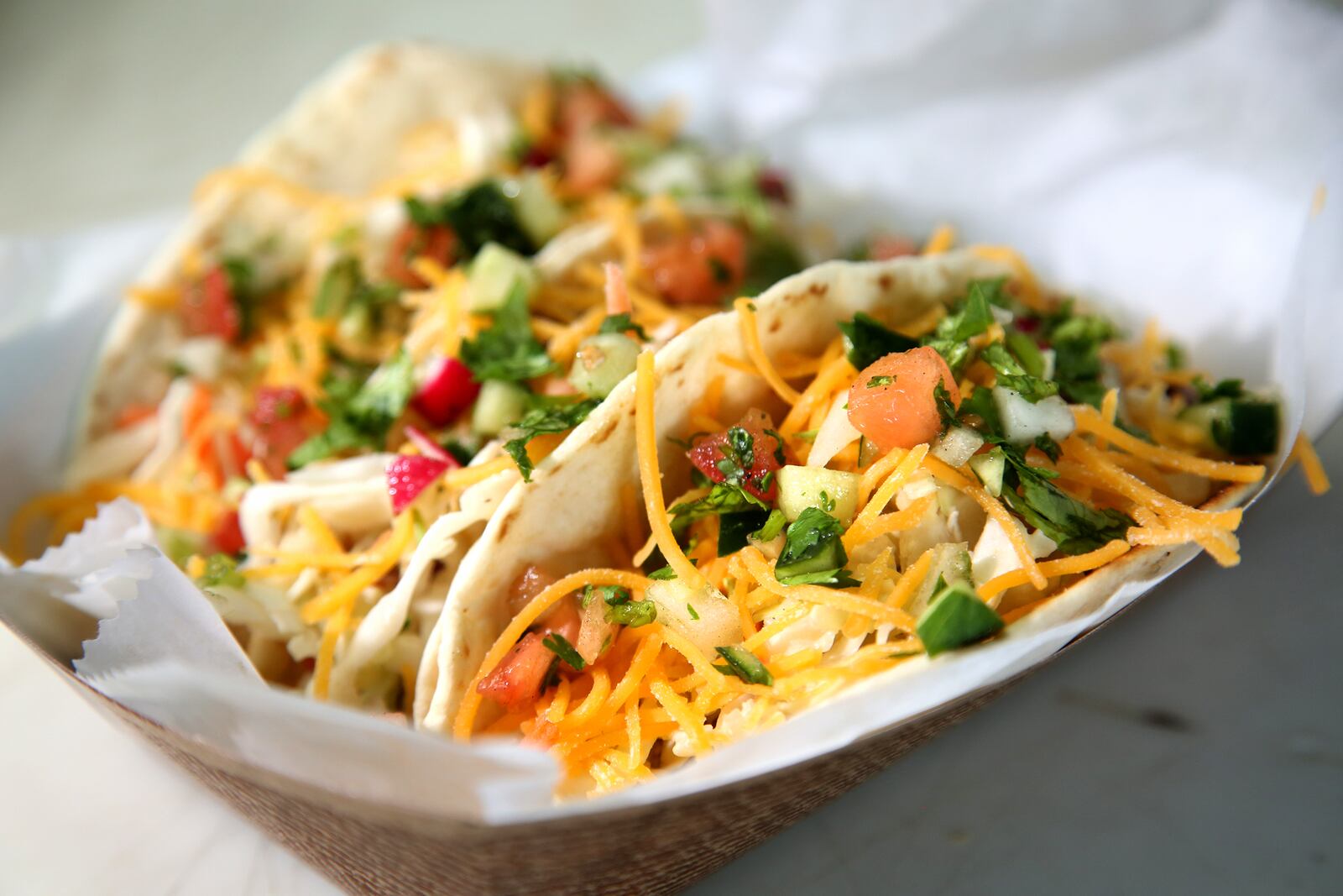 Three Amigos Tacos, made with smoked chicken breast or pulled pork, are a popular item on the Dayton Urban BBQ food truck menu. LISA POWELL / STAFF