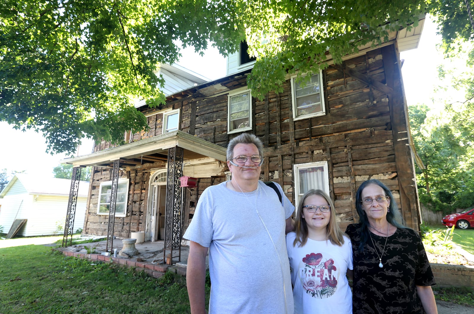 Jerry Schutt and his wife Jodi Vuotto, pictured with their granddaugher Bailey Anthony, are the owners of a home at 2021 Gipsy Dr. in Harrison Twp. Recently they discovered the home was made of logs covered with layers of cedar and aluminum siding. The home is linked to folklore about the Stanley family gypsies and that it was once their summer home.  LISA POWELL / STAFF