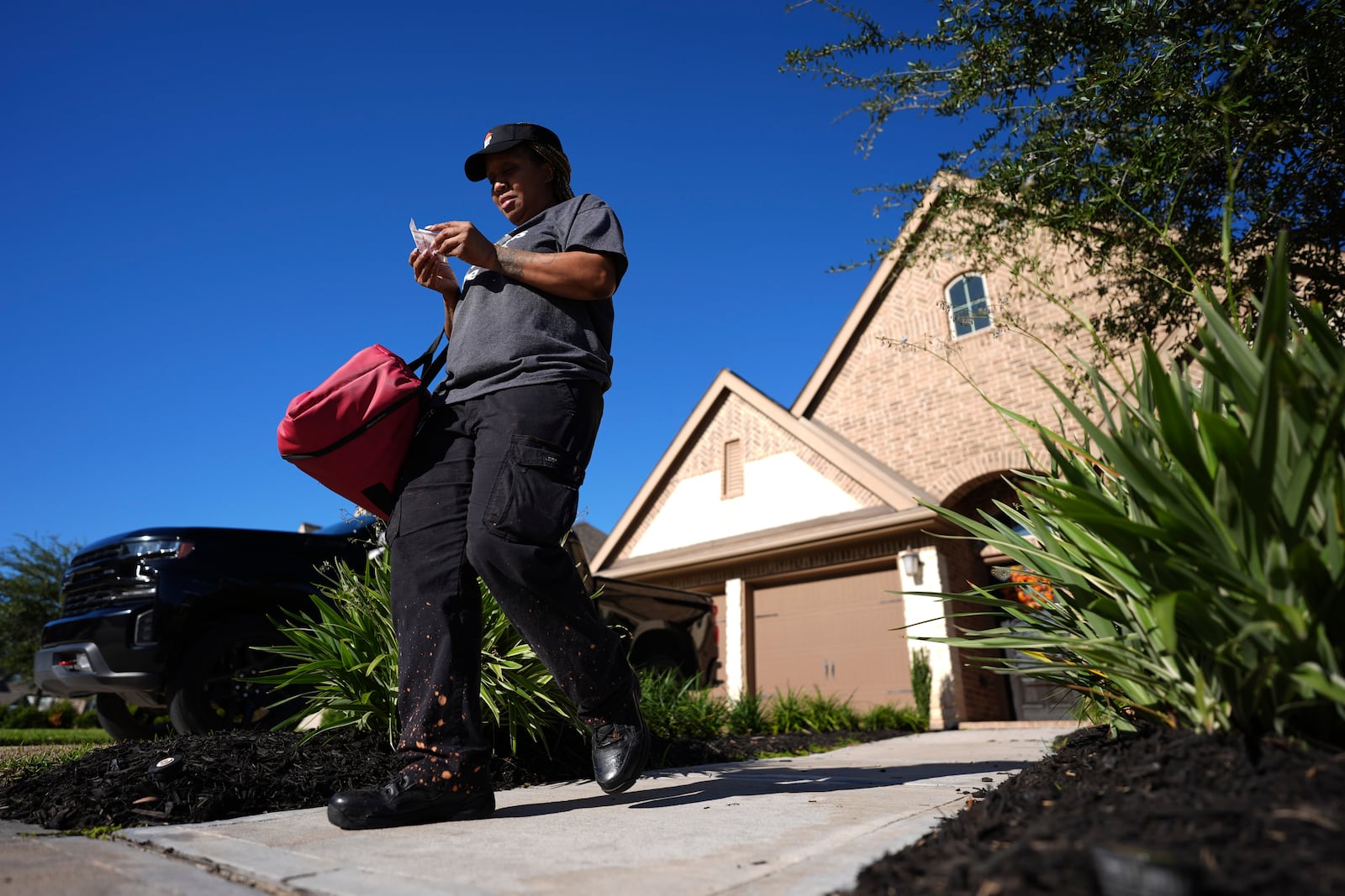 TiAnna Yeldell makes a delivery for Pizza Hut, Thursday, Nov. 14, 2024, in Missouri City, Texas. (AP Photo/Eric Gay)