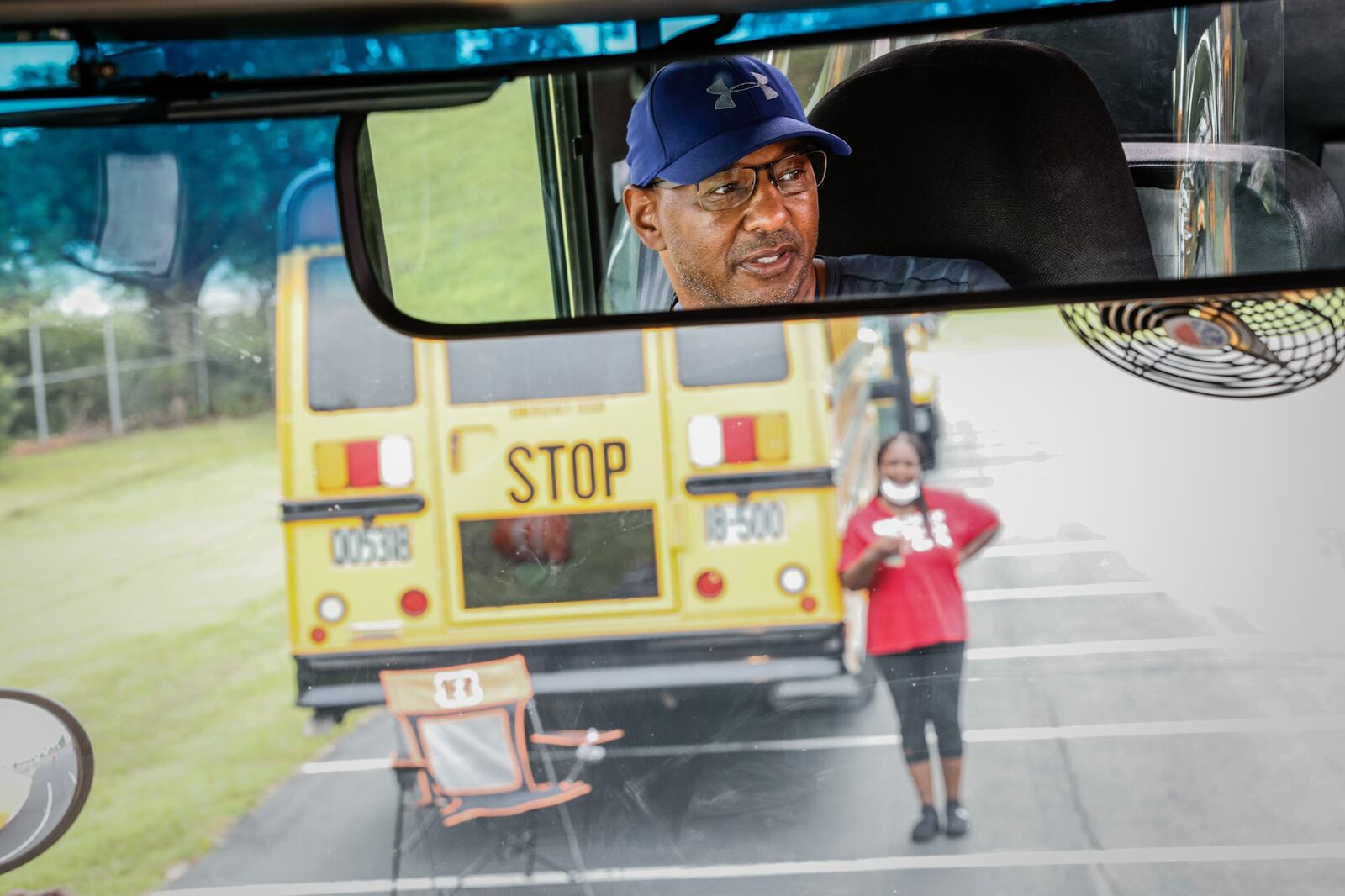 Dayton public schools bus driver in training, Barry Payne, in the mirror, learns to drive a school bus at the Welcome Stadium parking lot Tuesday August 9, 2022. JIM NOELKER/STAFF