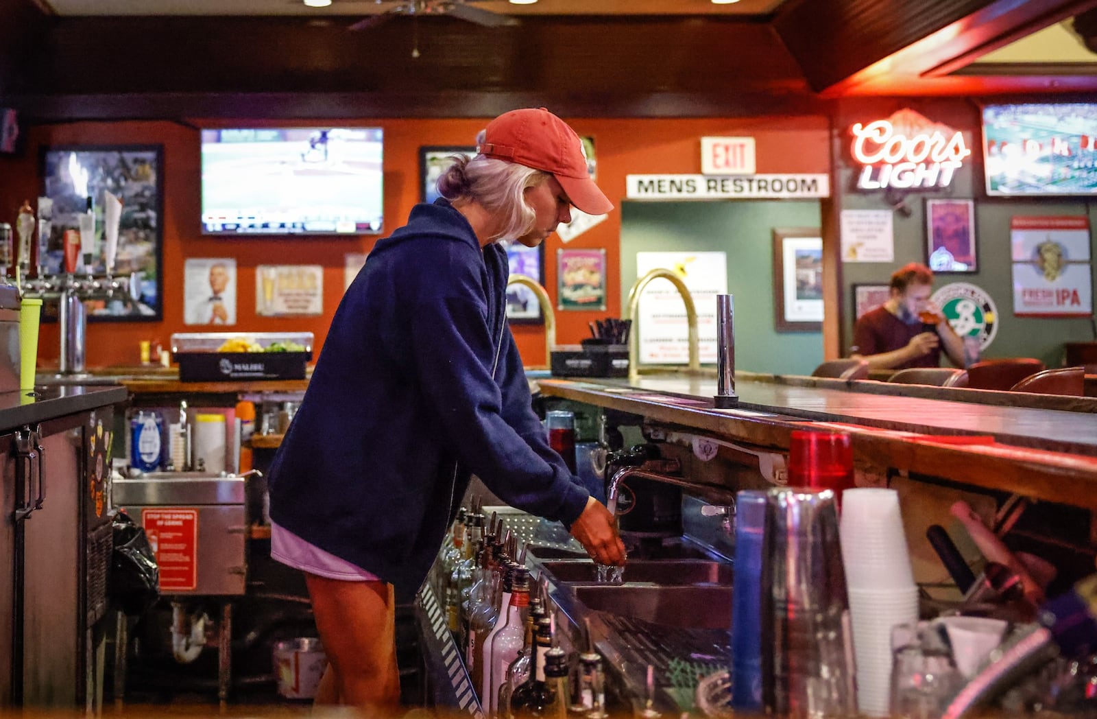 Little York Tavern & Pizza bartender, Alexandria Back readies the barroom  for a busy Friday afternoon. The Little York Tavern applied for a sports gambling kiosks. Ohio sports gambling will start Jan. 1, 2023. JIM NOELKER/STAFF