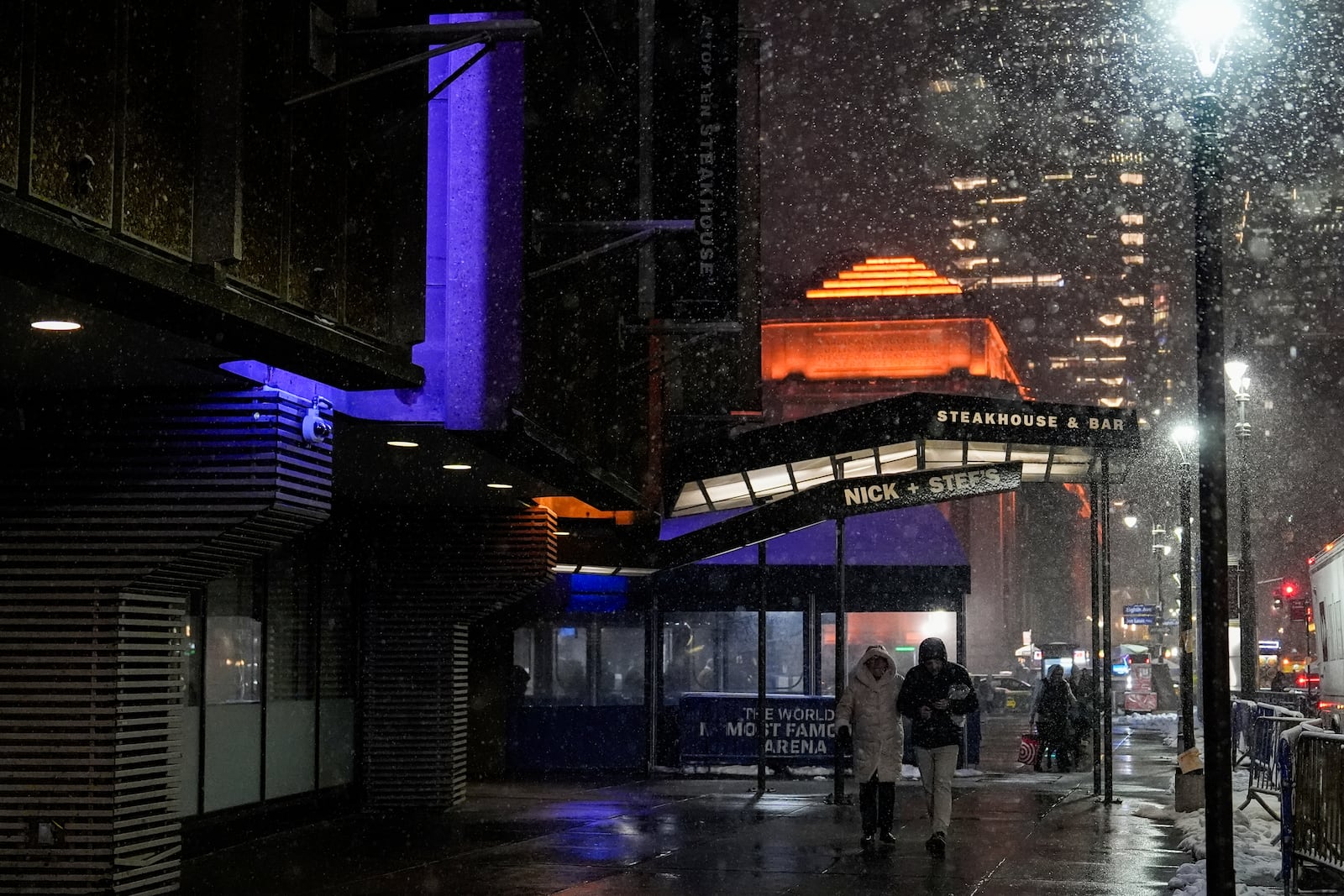 People walk through snow outside Madison Square Garden, Tuesday, Feb. 11, 2025, in New York. (AP Photo/Julia Demaree Nikhinson)