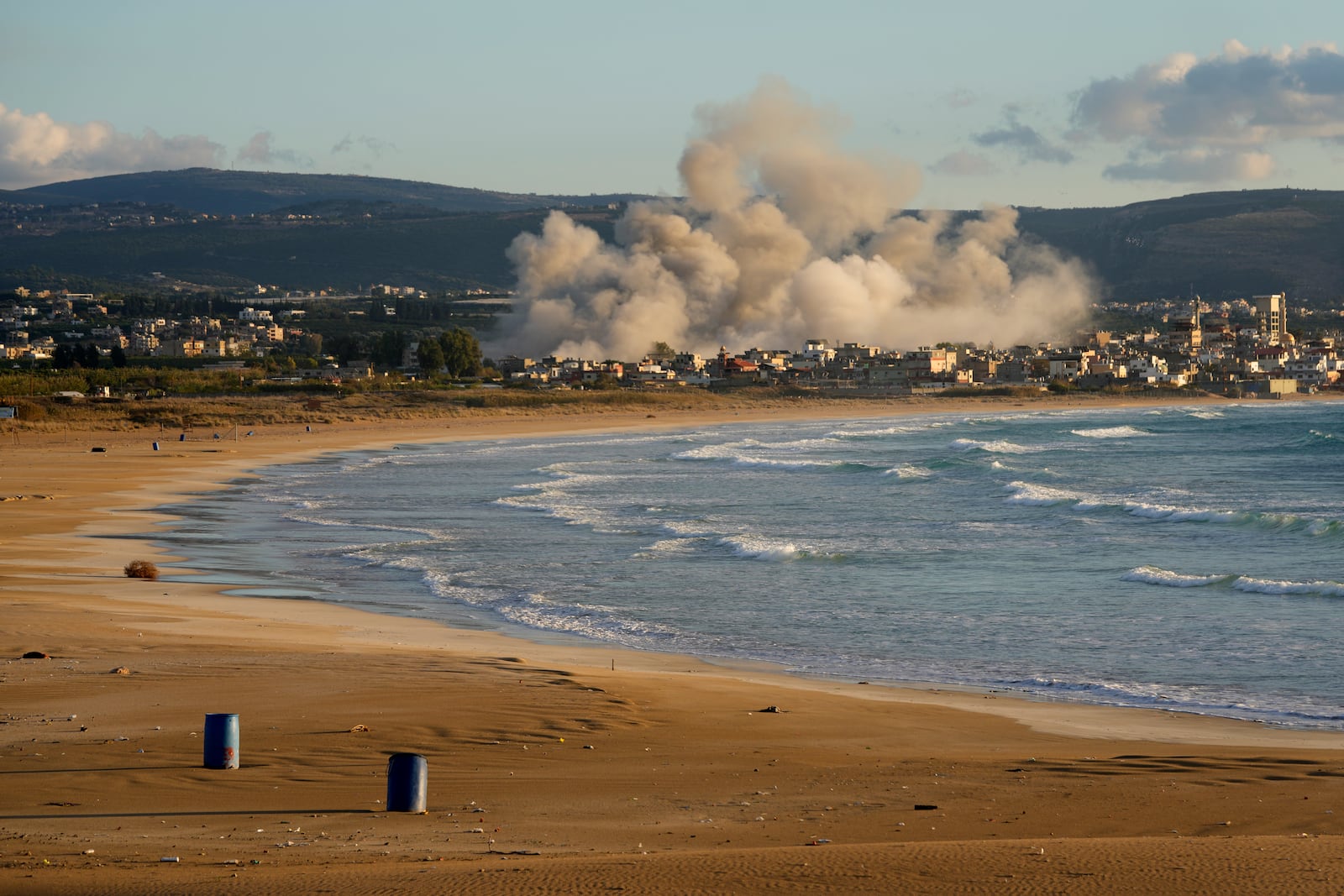 Smoke rises between buildings hit in Israeli airstrikes near the Palestinian refugee camp of Rashidiyeh, as seen from Tyre city, south Lebanon, Tuesday, Nov. 26, 2024. (AP Photo/Hussein Malla)