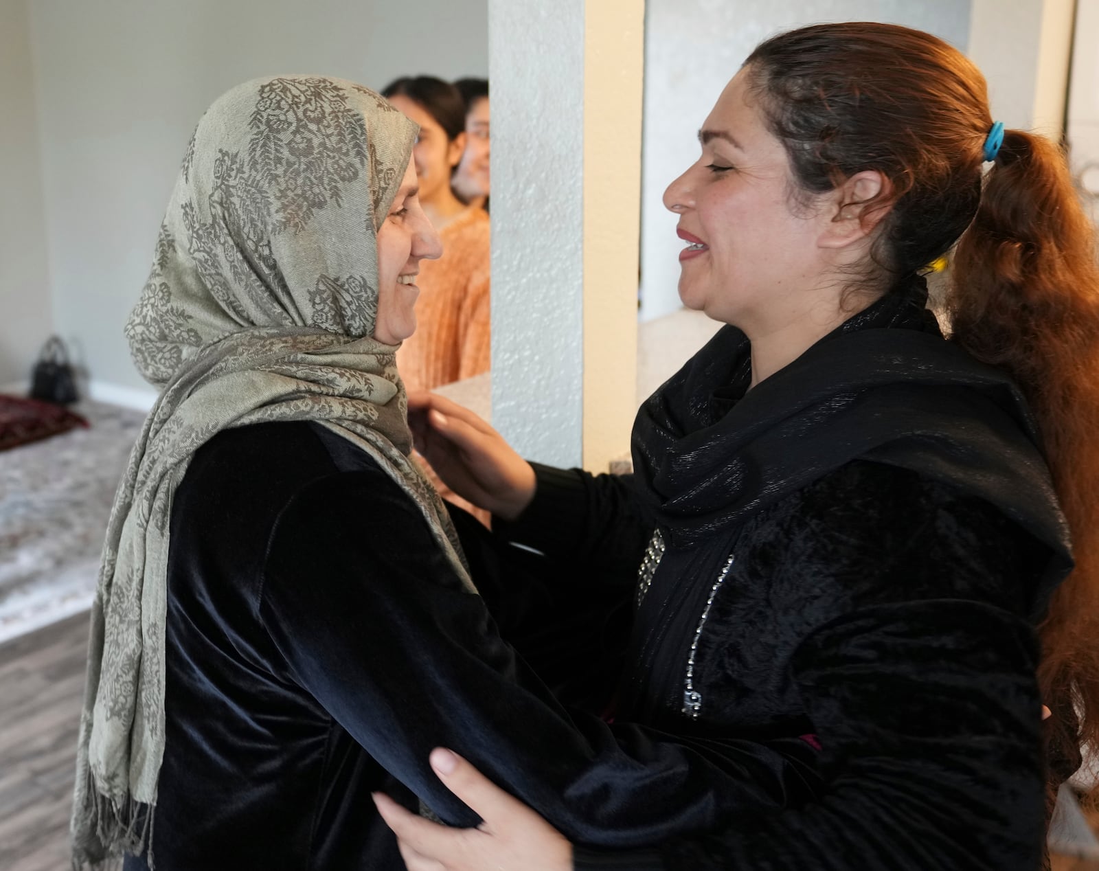 Pawlasha Rahimi, left, and Noria Sdeqi, who met weeks ago in a resettlement camp in Albania after leaving Afghanistan, hug after reuniting in Rancho Cordova, Calif., Wednesday, March 12, 2025. (AP Photo/Rich Pedroncelli)