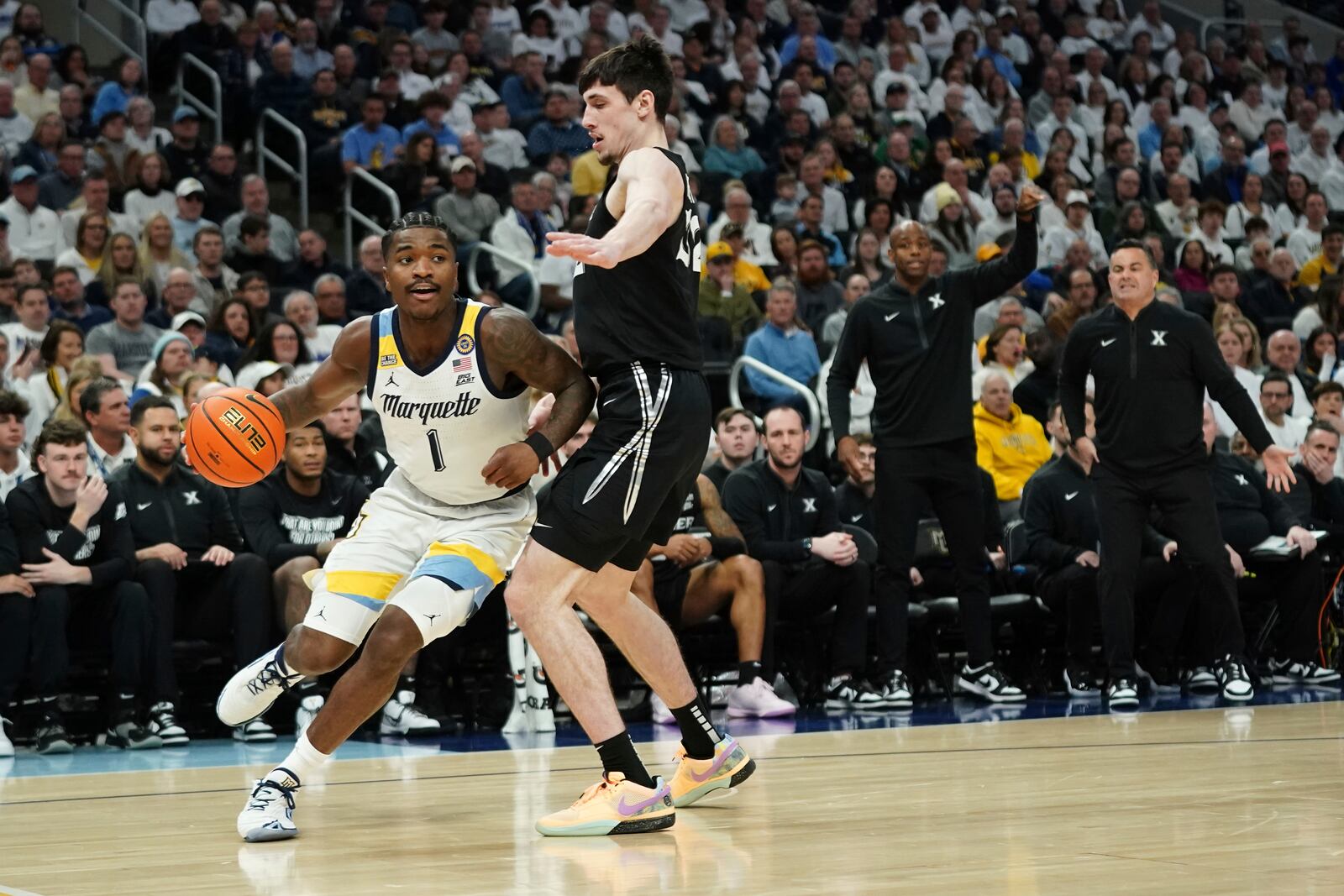 Marquette's Kam Jones (1) drives to the basket against Xavier's Zach Freemantle during the first half of an NCAA college basketball game Saturday, Jan. 18, 2025, in Milwaukee. (AP Photo/Aaron Gash)