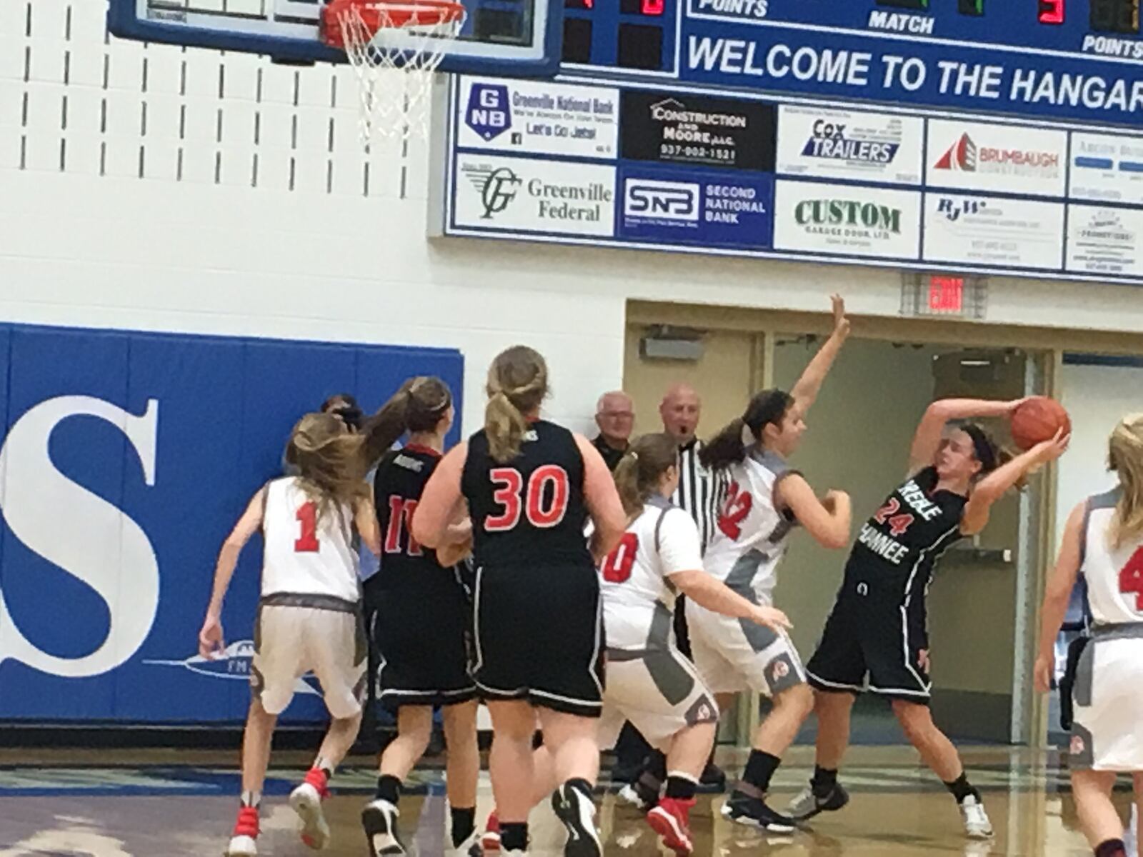 Carlisle’s Cami Glover (32) is on the edge of a crowd guarding Preble Shawnee’s Logan Hollon (24) during a Division III sectional game Saturday at Franklin Monroe. RICK CASSANO/STAFF