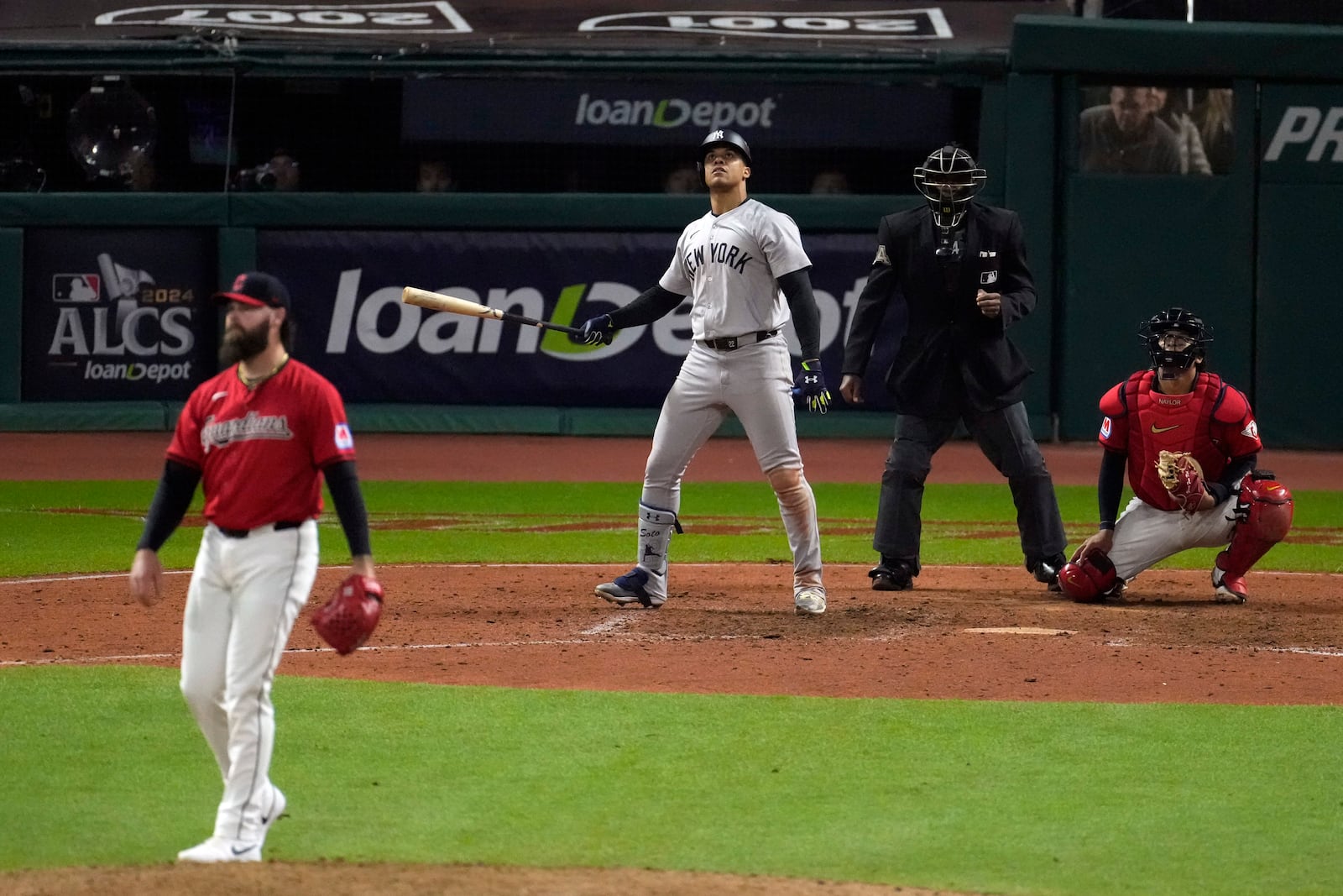 New York Yankees' Juan Soto, center, watches his three-run home run off Cleveland Guardians pitcher Hunter Gaddis, left, during the 10th inning in Game 5 of the baseball AL Championship Series Saturday, Oct. 19, 2024, in Cleveland. (AP Photo/Jeff Roberson)