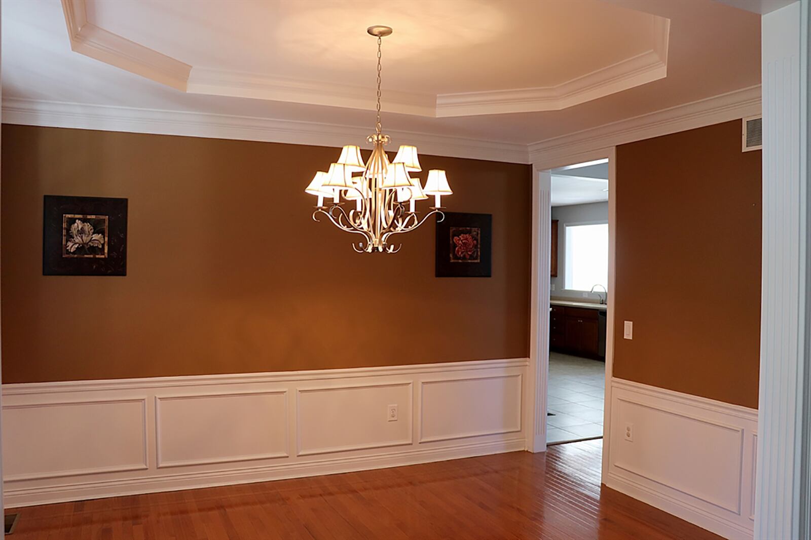 The dining room has wainscoting and an octagonal tray ceiling with hanging light fixture. CONTRIBUTED PHOTO BY KATHY TYLER