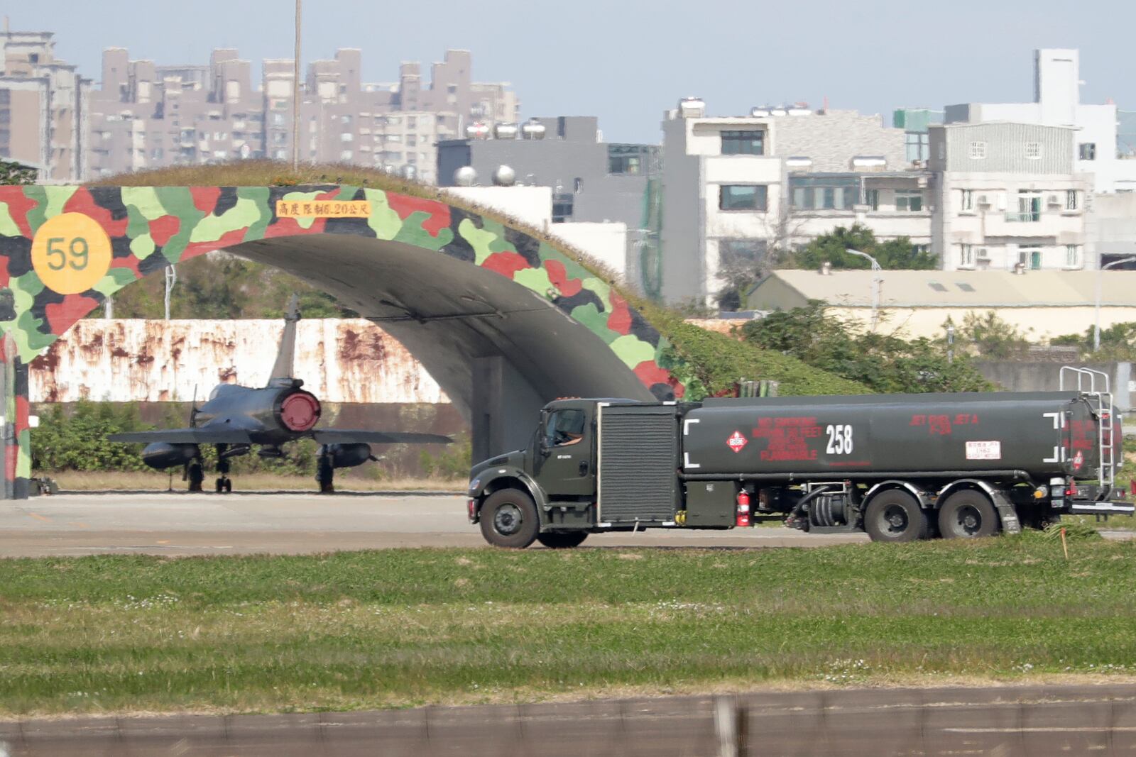 Taiwanese air ground troop vehicle moves past an airplane at an airbase in Hsinchu, northern Taiwan, Wednesday, Dec. 11, 2024, as Taiwan's Defense Ministry said Tuesday it detected Chinese naval ships and military planes engaged in training. (AP Photo/Chiang Ying-ying)